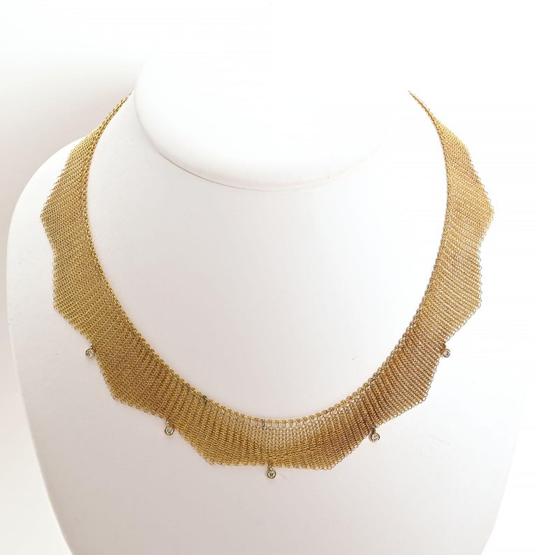 Delicate 18 karat gold mesh necklace by Tiffany with 5 diamonds. The necklace has a scalloped design with a diamond in the shorter part of each scallop. Total diamond weight is approximately .5 carats. The necklace measures 16 inches in length. Each