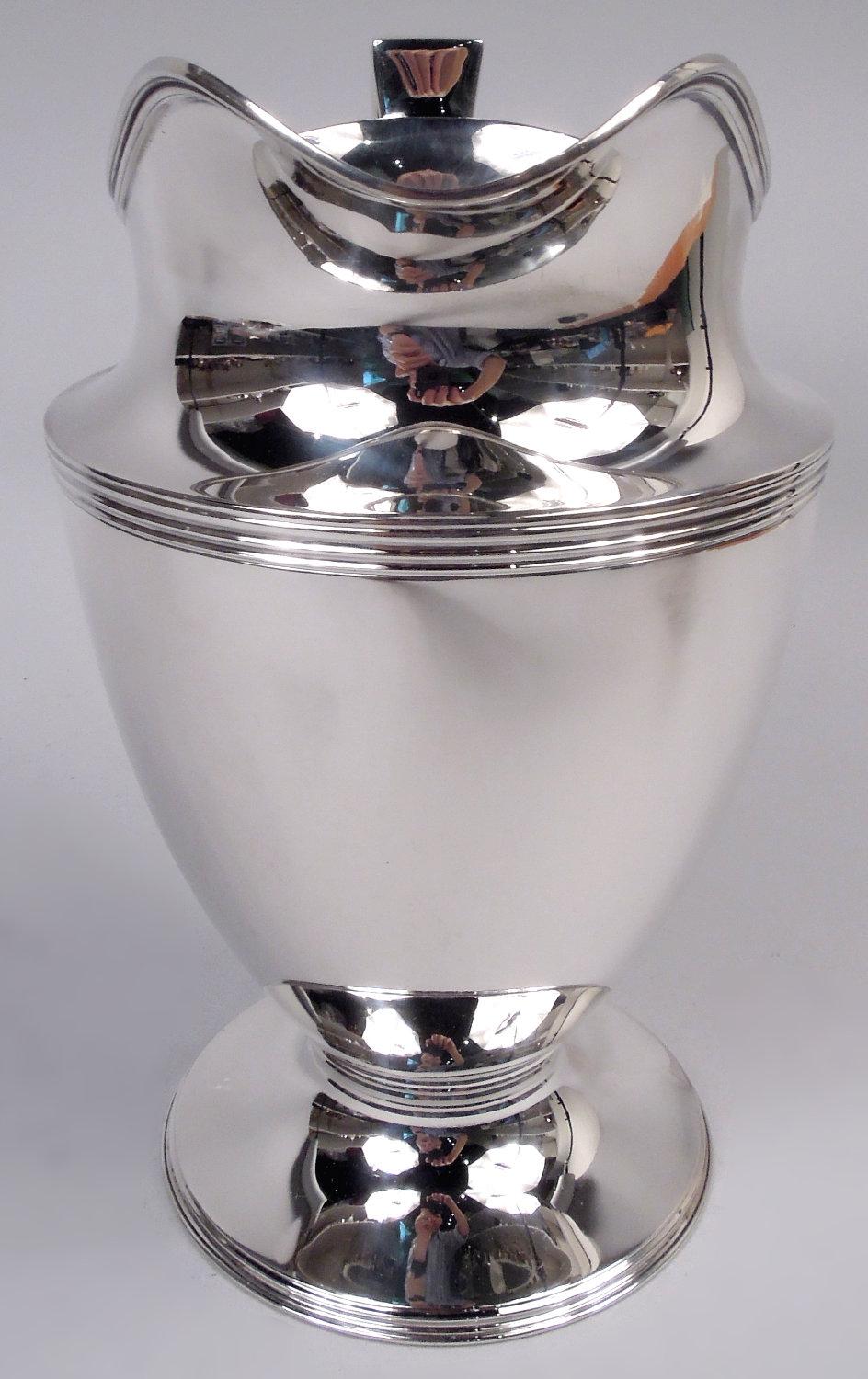 Jarra de agua Hamilton de plata de ley. Fabricado por Tiffany & Co. en Nueva York, hacia 1911. Cuerpo curvo y ahusado, pie elevado, asa de ménsula con volutas y boca de casco. Reed. Completamente marcada, incluido el sello del fabricante, el n.º de
