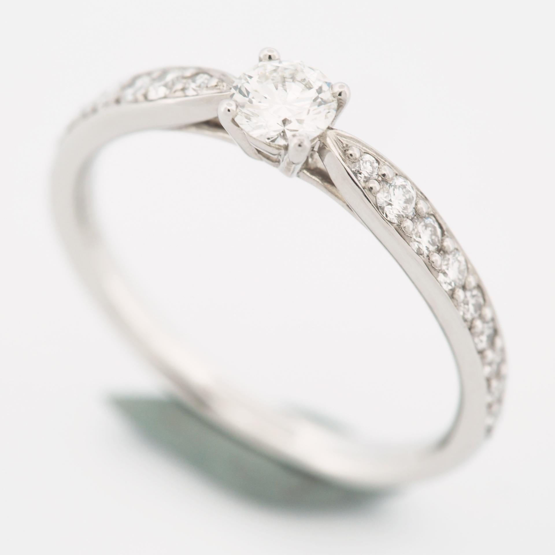 Item: Tiffany Harmony Solitaire Diamond Ring 
Stones: Diamond / 0.19ct (center stone) with 18 pave diamonds (approx. 0.11ct)
Color: I
Clarity:VS2
Polish: Excellent
Symmetry: Excellent
Fluorescence: None
Metal: Platinum 950
Ring Size: SIZE 5.5 UK