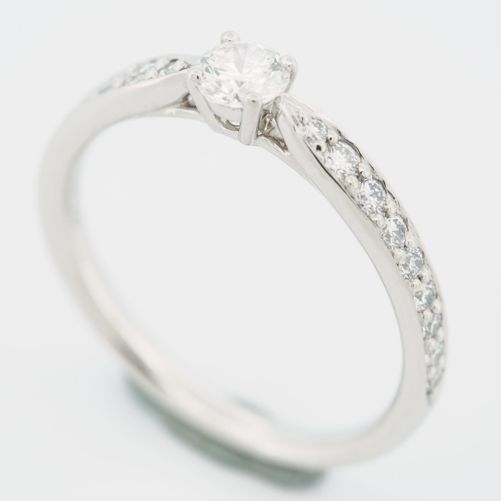 Article : Authentique bague à diamant solitaire Harmony de Tiffany 
Pierres : Diamant / 0,20ct (pierre centrale) avec 18 diamants pavés (approx. 0,11ct)
Couleur : F
Clarté:VS2
Polonais : Excellent
Symétrie : Excellent
Fluorescence : Aucune
Métal :