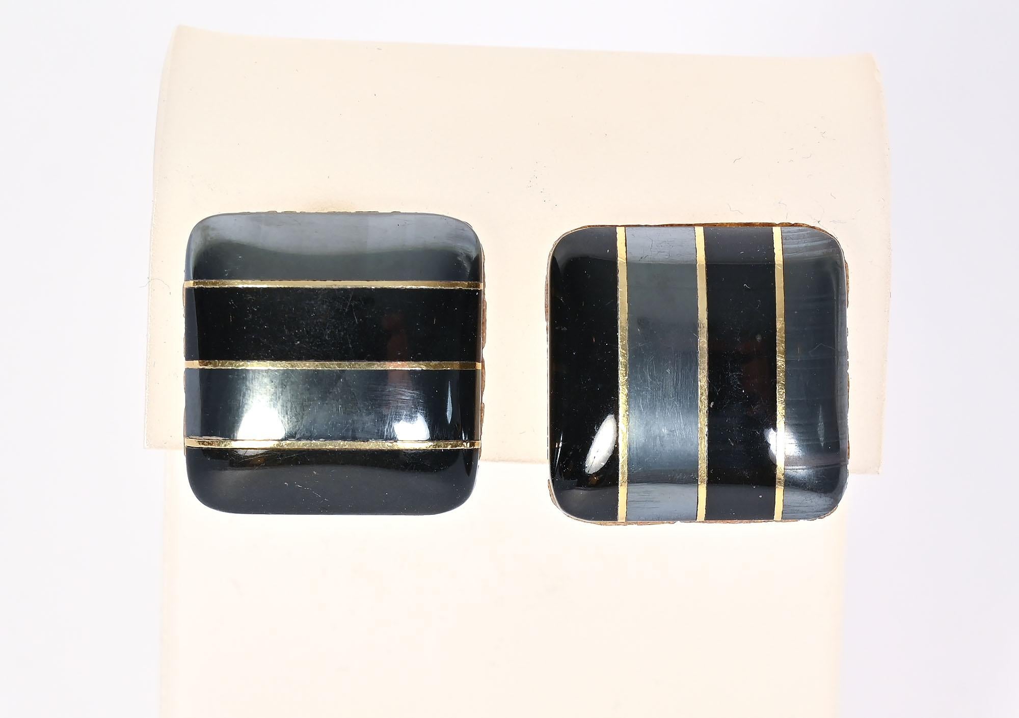 Unusual pair of fraternal twin earrings by Tiffany. The two are the same design but are set at different angles. Both pairs have two rows of hematite and two of black jade, separated by a band of gold.
The earrings have clip backs that can be