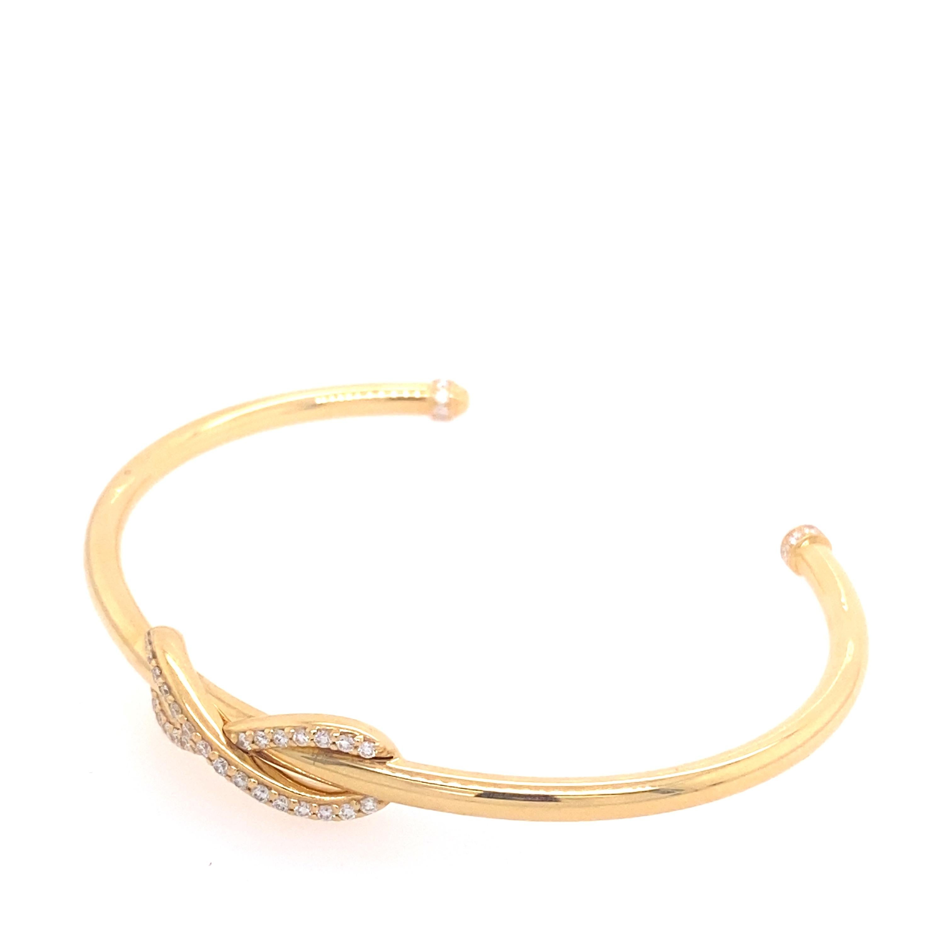 This classic Tiffany & Co. Diamond Infinity Cuff is a sleek, modern, 18kt yellow gold piece with 0.39ctw in round diamonds encrusting the infinity symbol and topping the ends of the cuff. The diamonds are of D-F color, VS-VVS quality. The bracelet