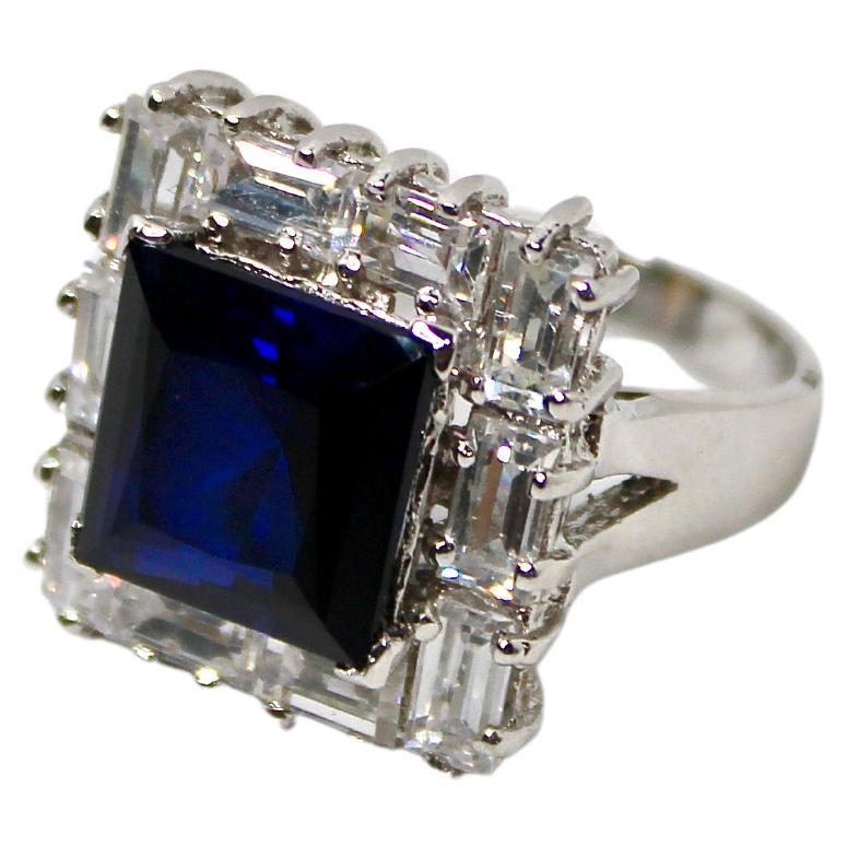 Este asombroso Anillo de Zafiro de Traje de Terciopelo Azul y Oro Blanco de 14 quilates de la década de 1970 es una pieza cautivadora que destila elegancia vintage y encanto atemporal. El anillo presenta un llamativo zafiro sintético de forma