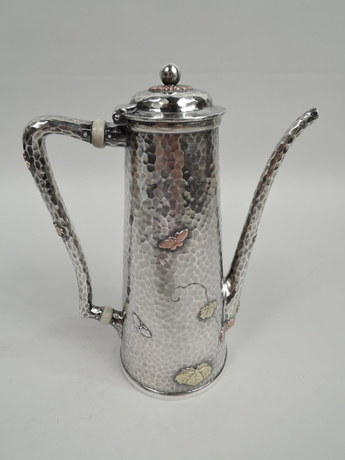 Japonesque mixed metal on sterling silver coffeepot. Made by Tiffany & Co. in New York, ca 1878. Truncated cone with gently scrolled bracket handle, tapering spout, and hinged and domed cover. Applied butterflies and leaves on engraved tendrils as
