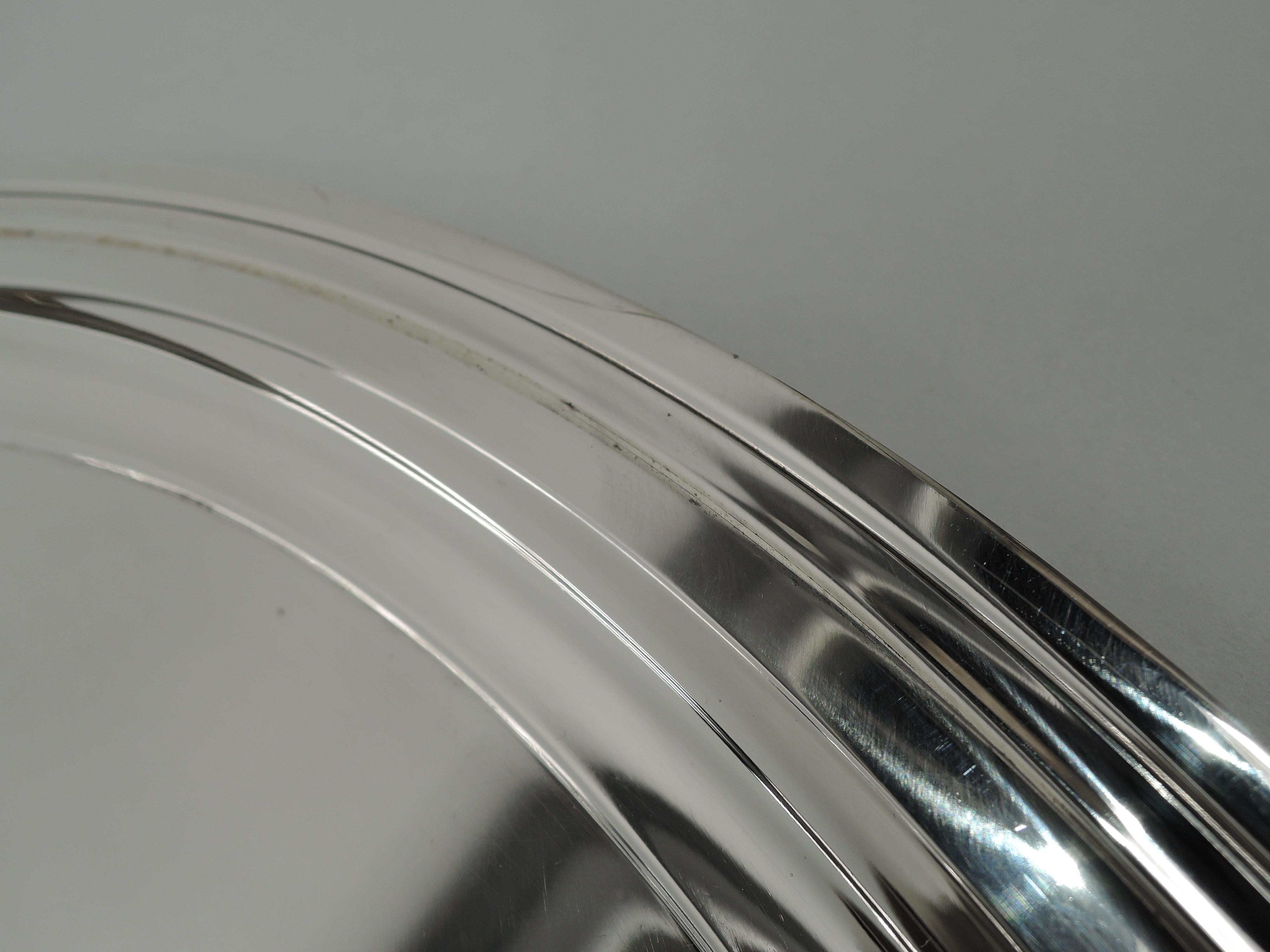 Large and Modern sterling silver serving tray. Made by Tiffany & Co. in New York. Round with stepped rim and deep well. Party size with nice heft and balance for circulating the hors d’oeuvres. Fully marked including maker’s stamp, pattern no.