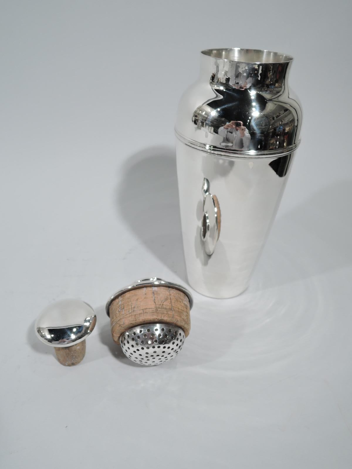 Art Deco sterling silver cocktail shaker. Made by Tiffany & Co. in New York, circa 1922. Tapering bowl with curved shoulder and short inset neck. Cover flat and overhanging with hemispheric strainer mounted to cork plug. Cover top has CAP with cork