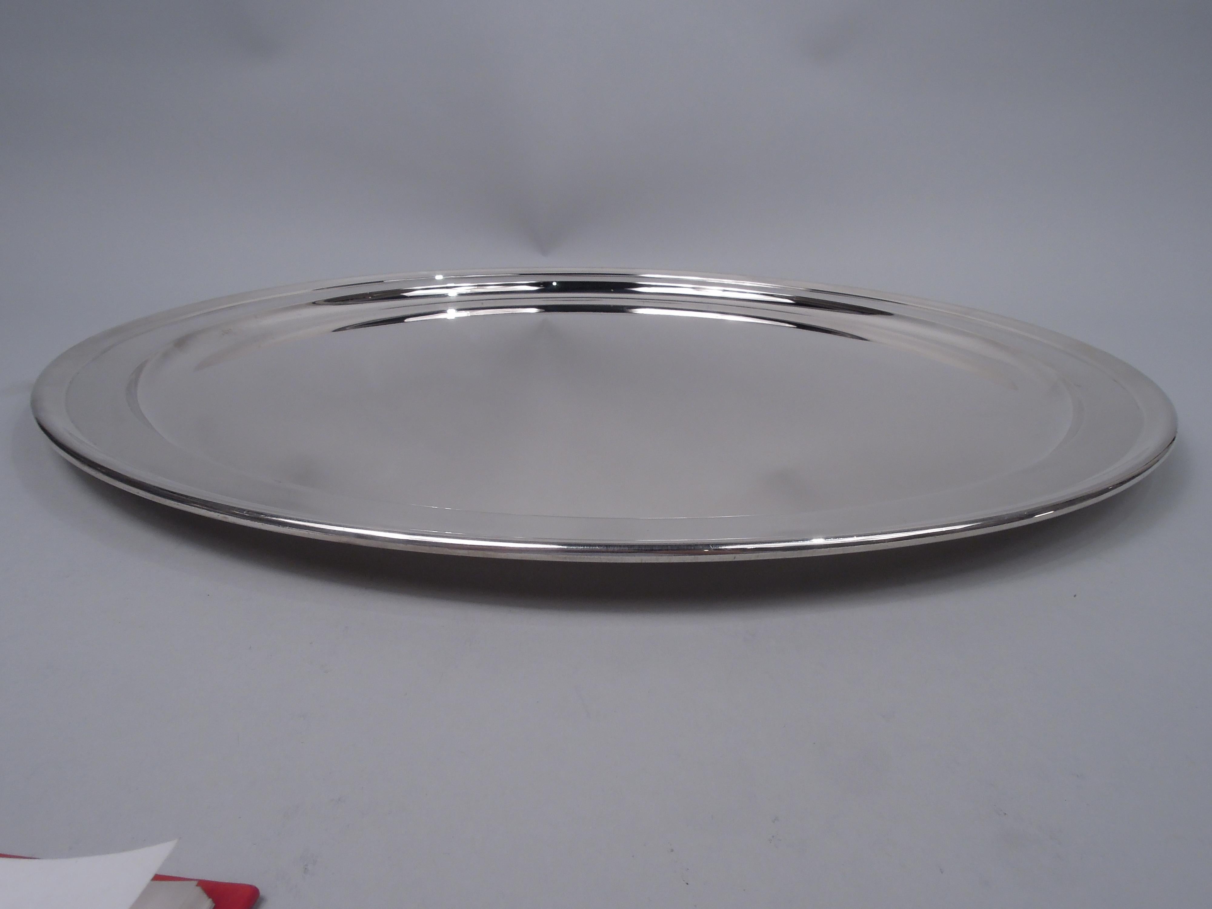 Large Midcentury Modern sterling silver tray. Made by Tiffany & Co. in New York. Round well with narrow shoulder and folded-over rim. Super functional with nice heft and balance. Fully marked including maker’s stamp, postwar pattern no. 23427, and