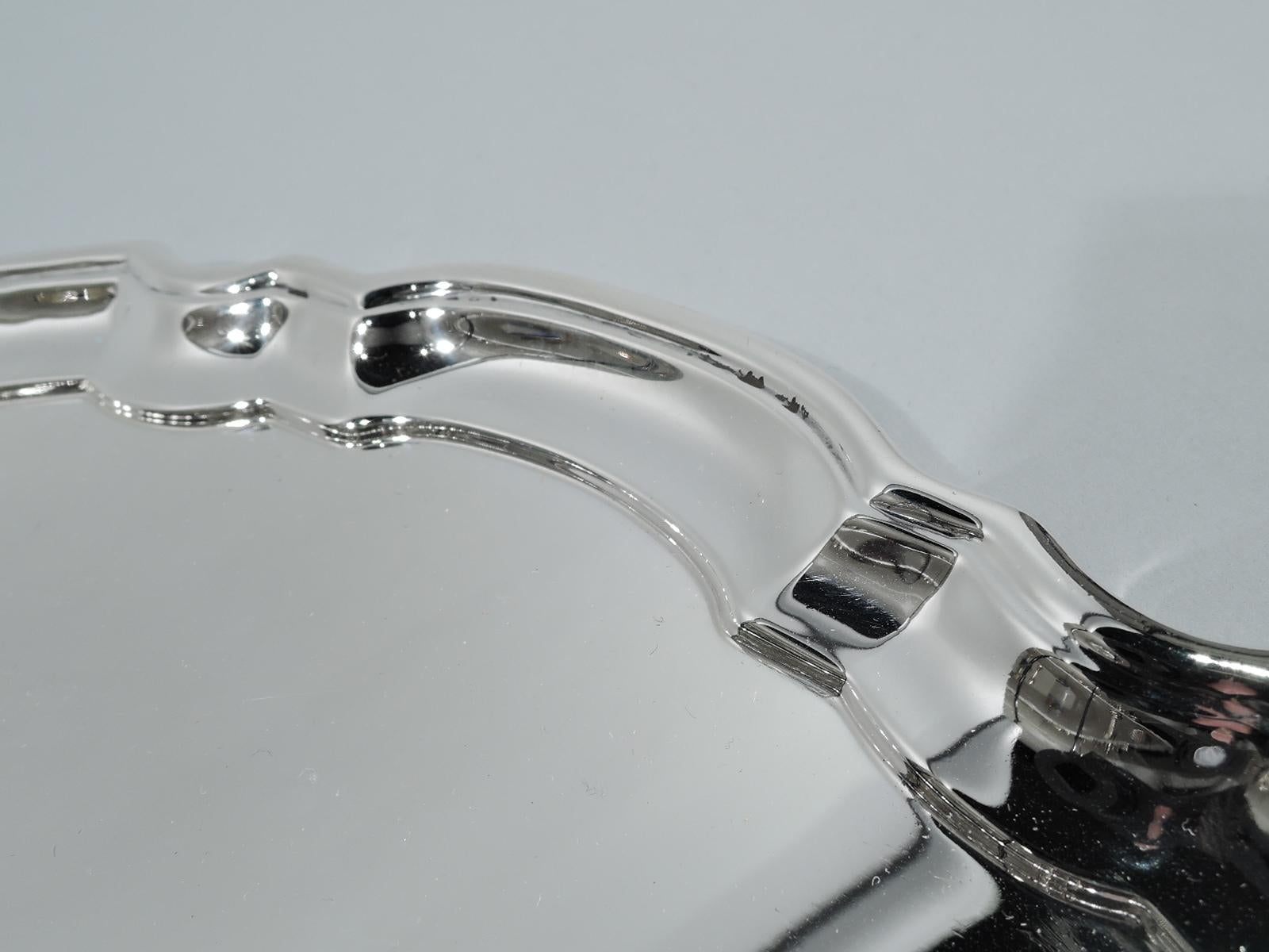 Traditional Georgian sterling silver tray. Made by Tiffany & Co. in New York, ca 1931. Round with molded curvilinear piecrust rim. Fully marked including pattern no. 21740 (first produced in 1931) and director’s letter m. Heavy weight: 21.5 troy