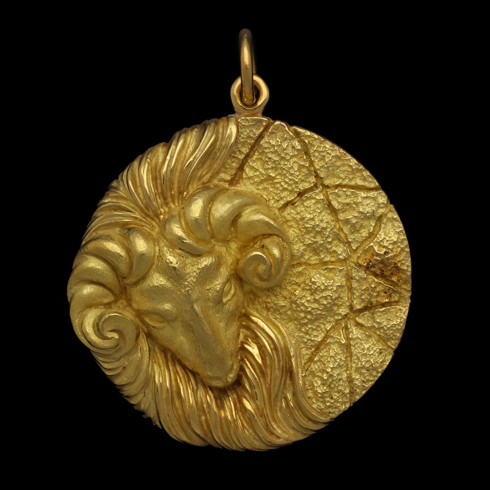 A large vintage Aries zodiac pendant by Tiffany & Co, circa 1970s, the circular disc pendant measuring 1.7” in diameter and formed of 18ct gold with a textured finish, on one side it depicts the head and shoulders of a ram in high relief, the