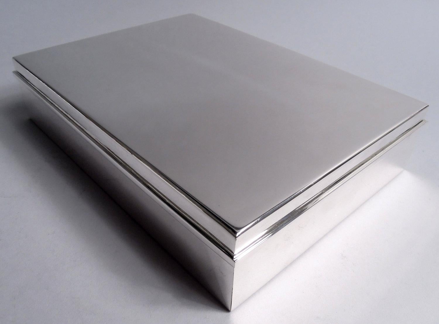 Caja grande de plata de ley moderna de mediados de siglo. Fabricado por Tiffany & Co. en Nueva York. Rectangular con lados rectos. Tapa plana y abatible con borde rectilíneo envolvente. Interior forrado de cedro y tabicado. Completamente marcada,
