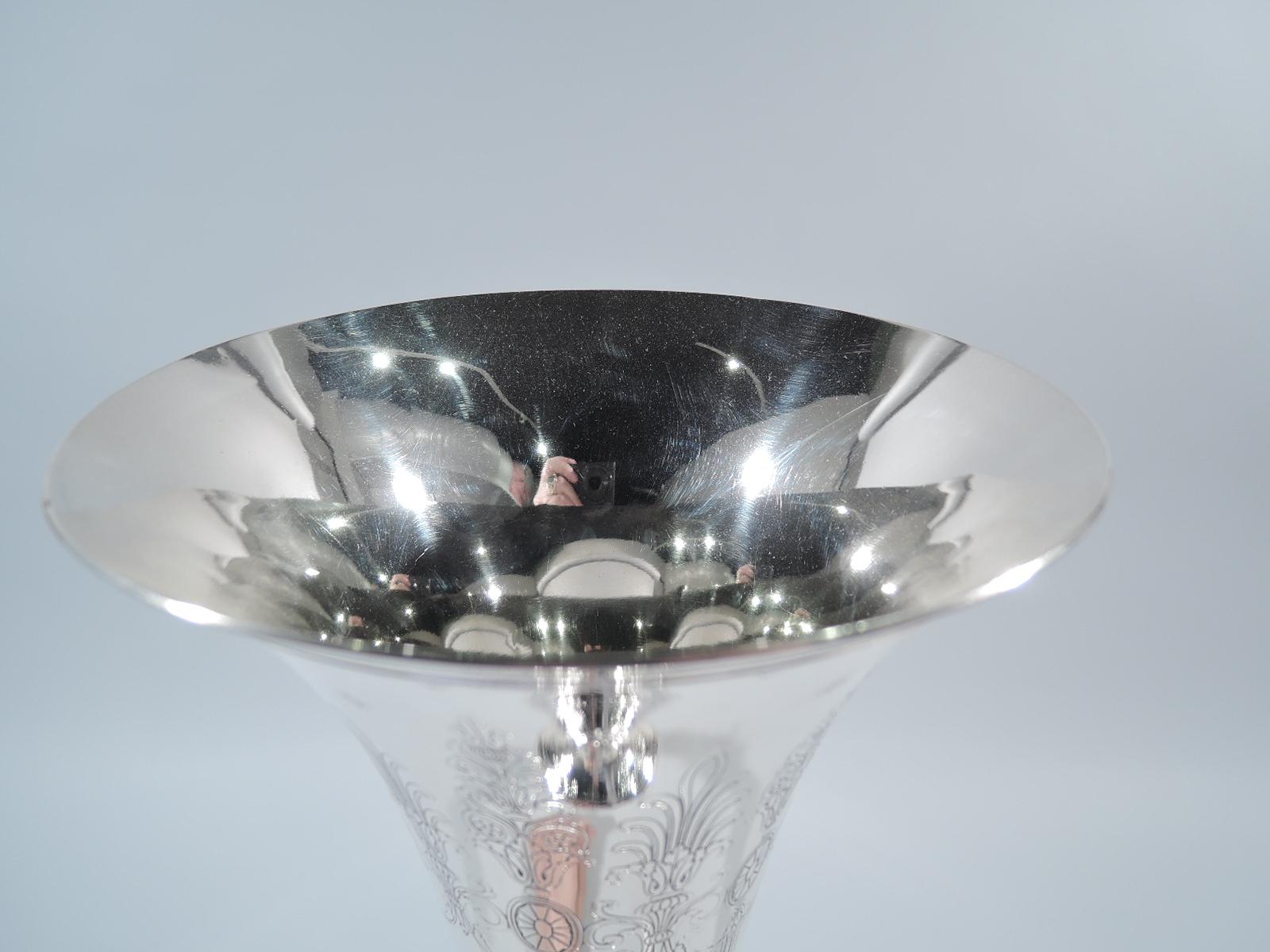 Neoclassical sterling silver trumpet vase. Made by Tiffany & Co. in New York, circa 1913. Tapering sides and stepped raised foot. Acid-etched repeating pattern with swags and paterae and armorial shield frames (all vacant). Stylized leaves at base.