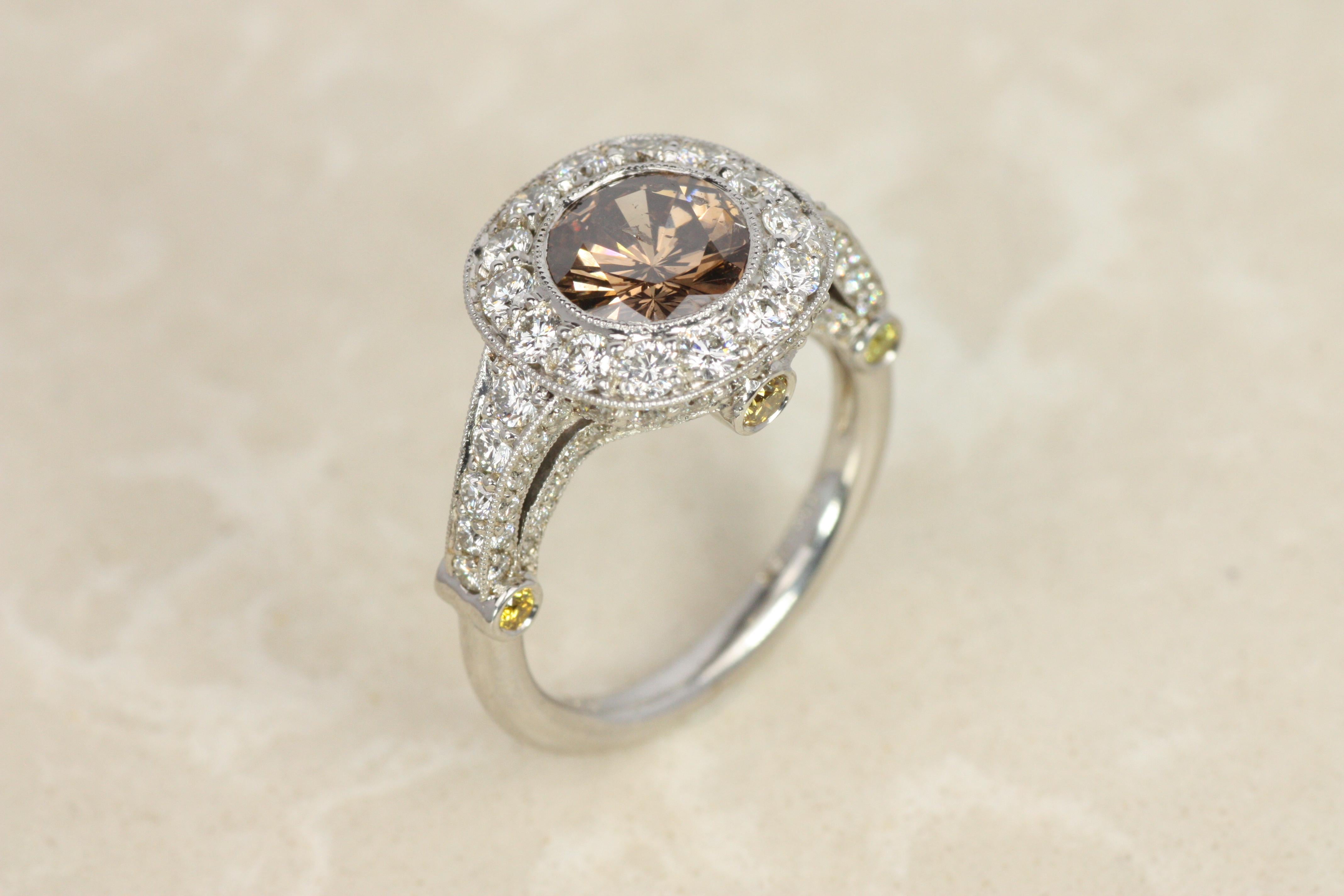 Dieser von Tiffany Legacy inspirierte Ring ist eine zeitlose Ode an den Vintage-Glamour und glänzt mit einem Trio aus seltenen Diamanten. Das Herzstück, ein schokoladenbrauner Diamant von 1,47 Karat, wird von weißen Brillanten umrahmt. Zwei