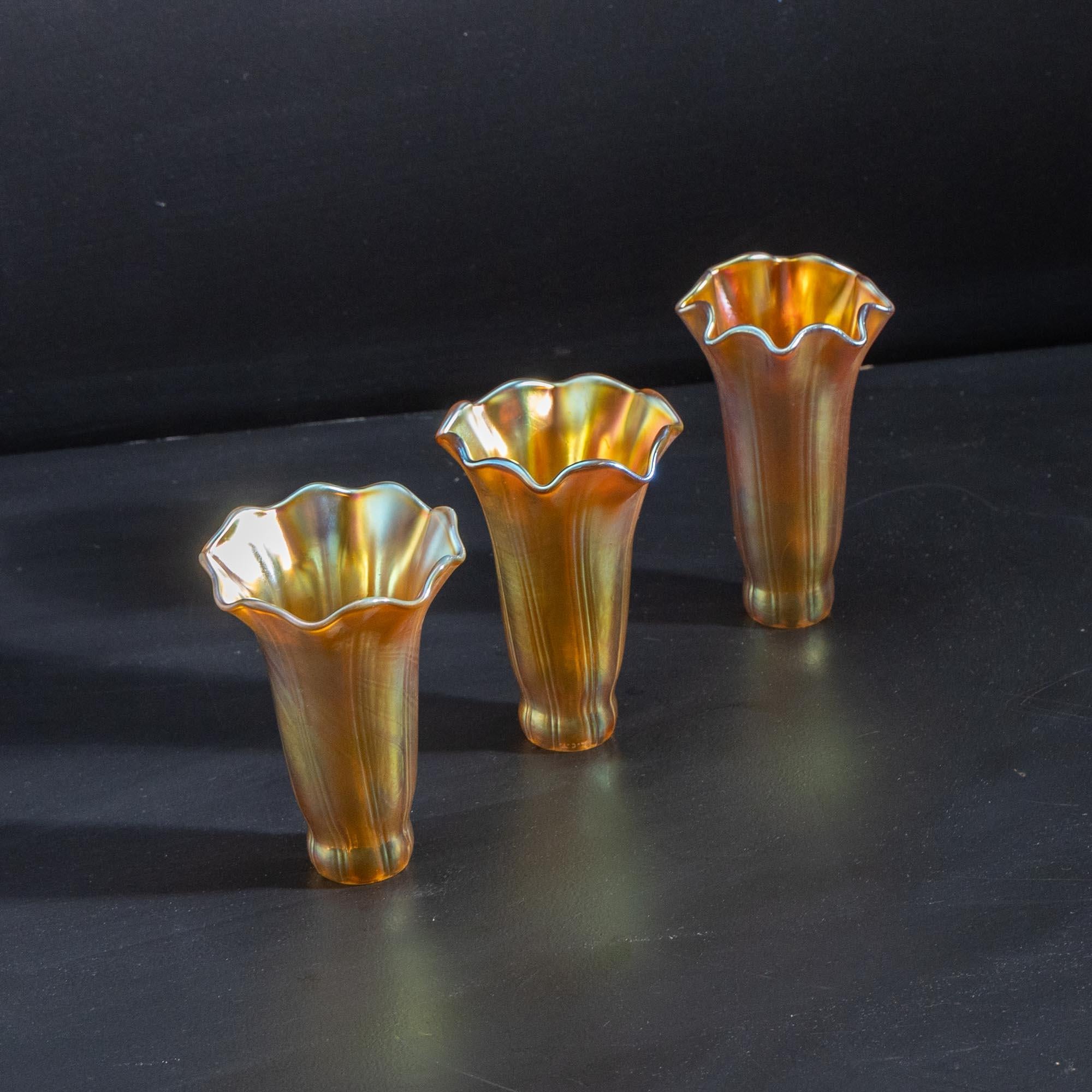 Three Tiffany Glass lampshades as spare parts, model Lily, with a lower diameter of 3 cm and an upper diameter of 8 cm. 
Two are the same style, one is slightly more angular and ends in pointier leaves. 