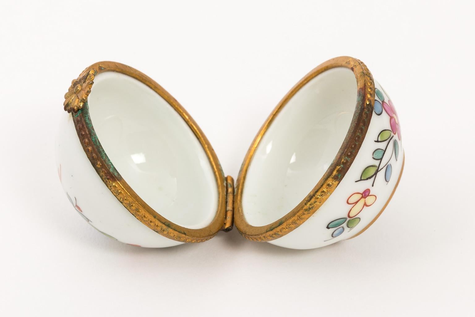 Tiffany & Co. exclusive Limoges hand painted porcelain box, circa 20th century. Please note of minor oxidation to the metal hardware due to wear with age.