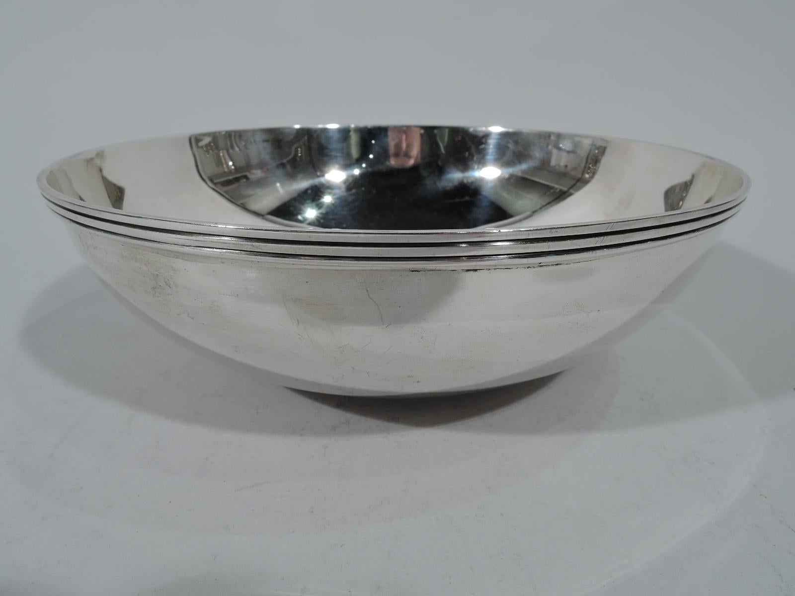 Mid-Century Modern sterling silver bowl. Made by Tiffany & Co. in New York. Circular well, curved sides, and reeded rim. Hallmark includes pattern no. 22843 and director’s letter M (1947-56). Measures: Weight 12.5 troy ounces.
