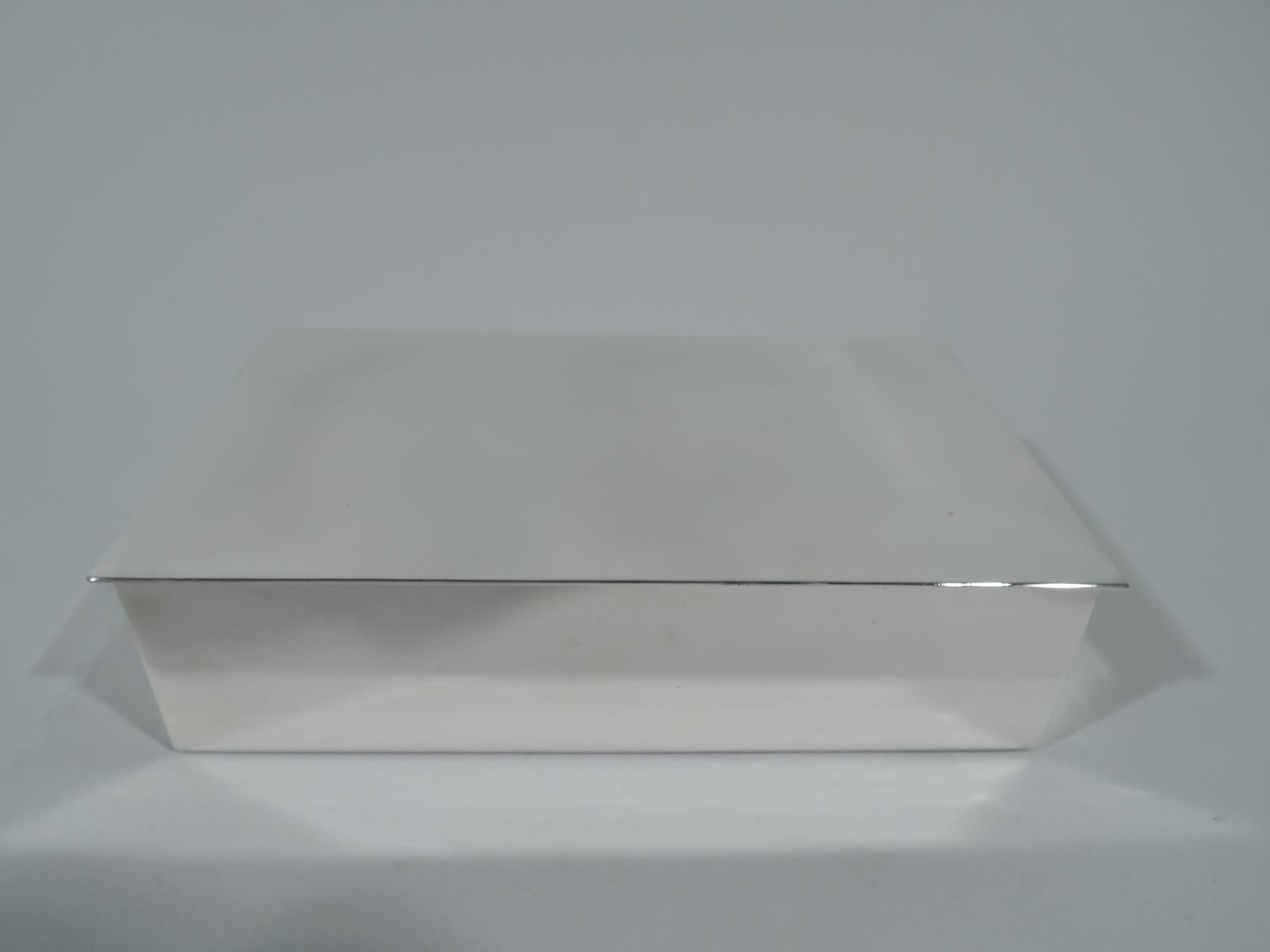 Mid-Century Modern sterling silver box. Made by Tiffany & Co. in New York. Rectangular with straight sides and crisp corners. Cover is hinged and flat with slight overhang. Box interior cedar lined. Austere and functional. Hallmark includes postwar