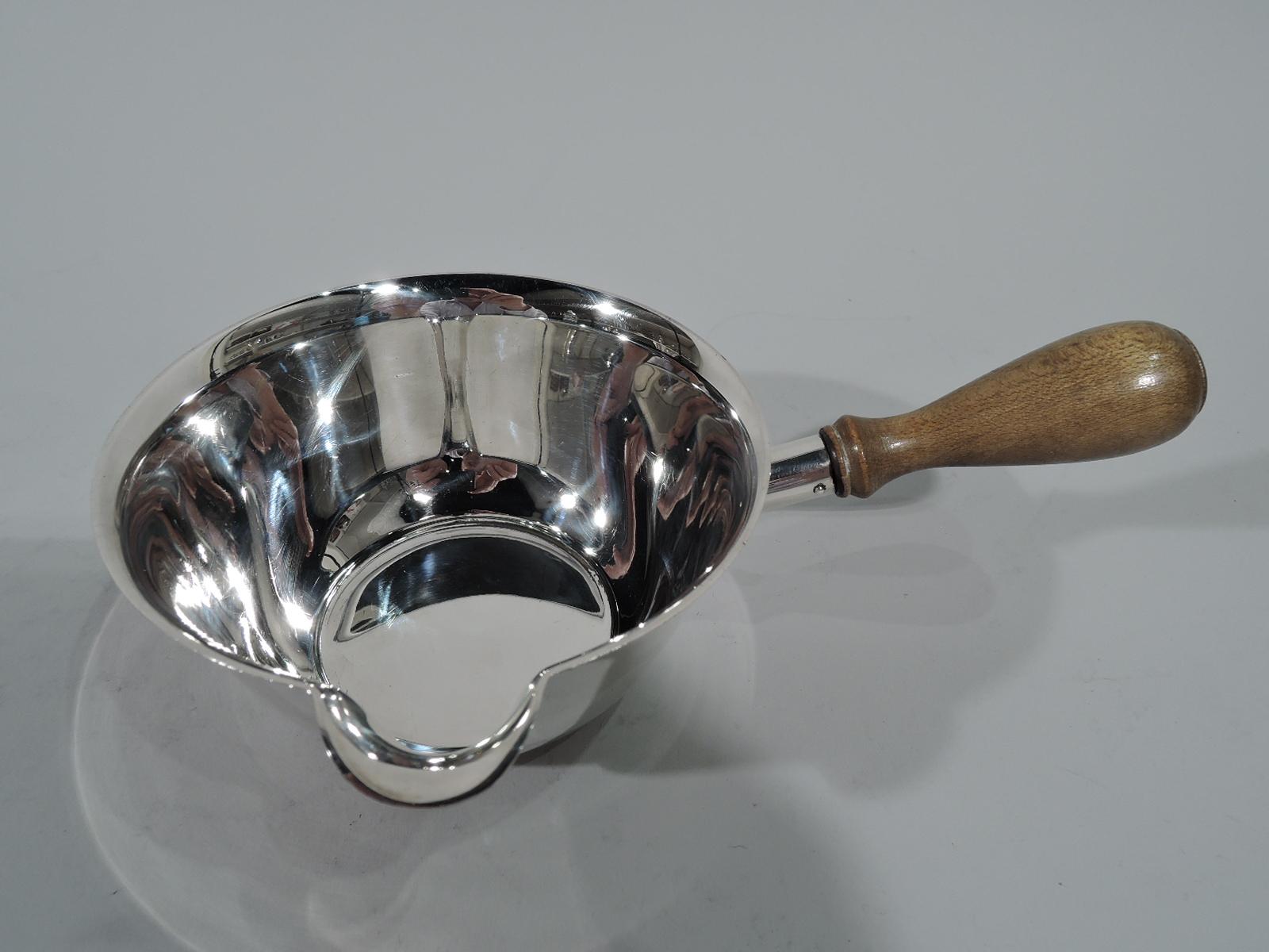 Mid-Century Modern sterling silver pipkin. Curved and tapering sides, V-Form lip spout, and stained-wood baluster handle. Hallmark includes pattern no. 22739 and director’s letter M (1947-56). Gross weight: 6.4 troy ounces.