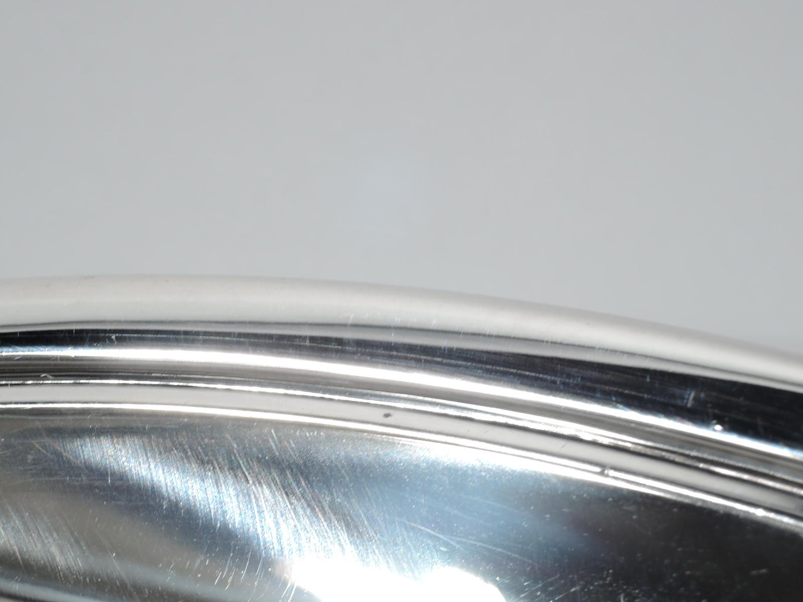 Midcentury classical sterling silver bowl. Made by Tiffany & Co. in New York. Round and curved bowl on 4 fluted scroll supports. Fully marked including pattern no. 23118 and director’s letter M (1947-56). Weight: 22.5 troy ounces.