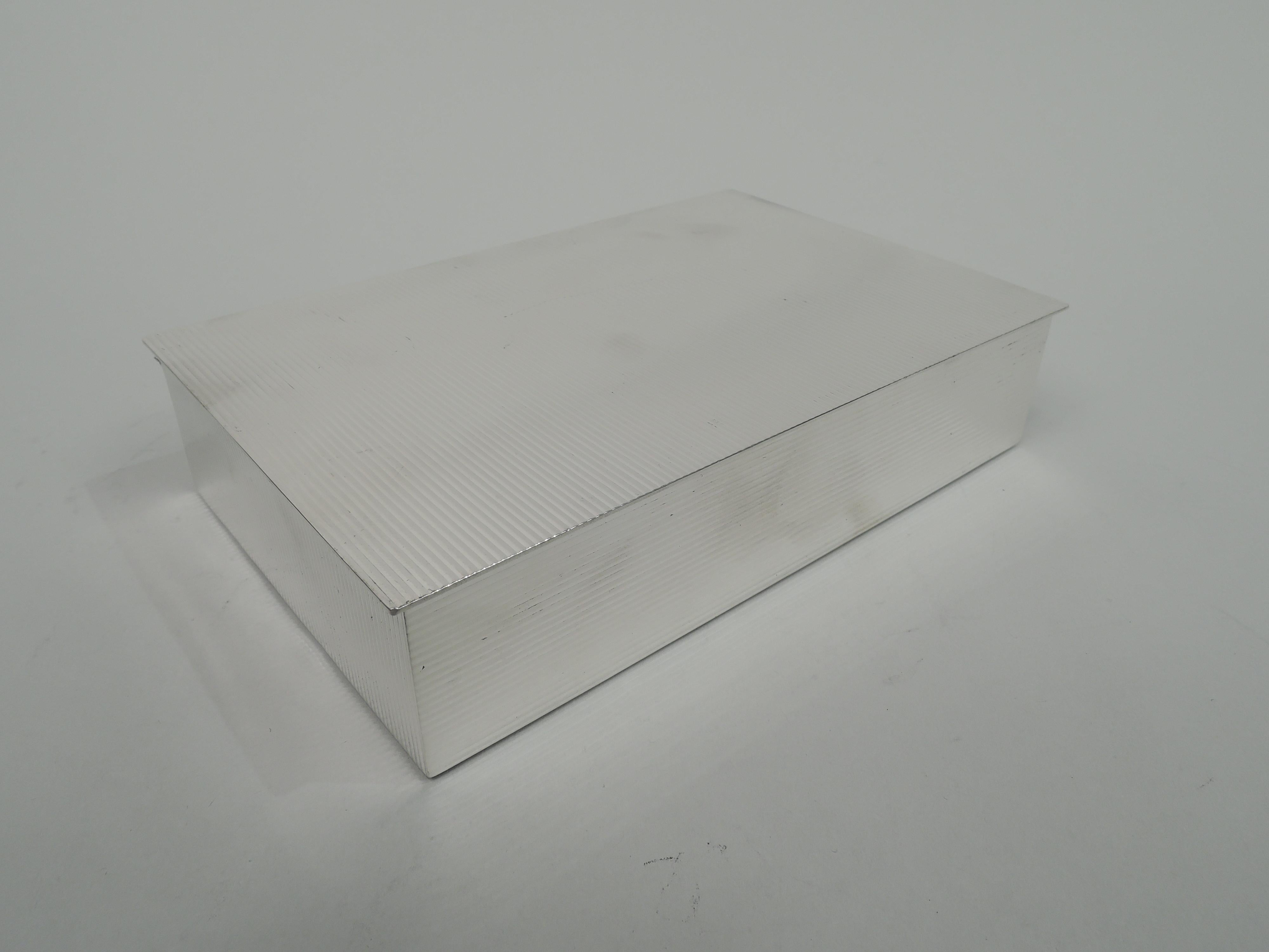 Midcentury Classical sterling silver box. Rectangular with straight sides. Cover flat and hinged with slight overhang. Allover horizontal ribbing with slightly illusionistic shimmer: Horizontal on front and back, and vertical on ends and cover top.