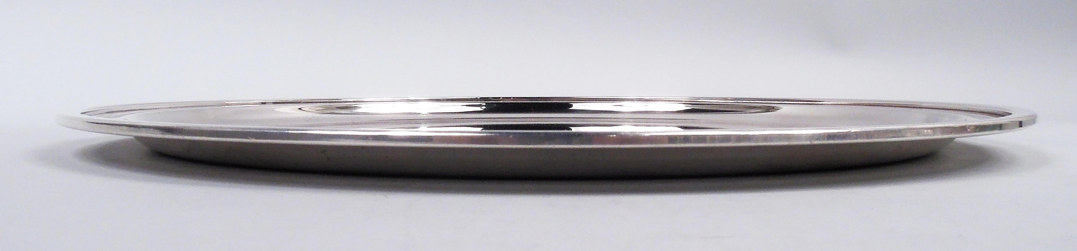 Plateau en argent sterling de style moderne du milieu du siècle. Fabriqué par Tiffany & Co. à New York. Puits rond et profond, épaule effilée et bord plat et étroit. Entièrement marqué, y compris le tampon du fabricant et le numéro de modèle