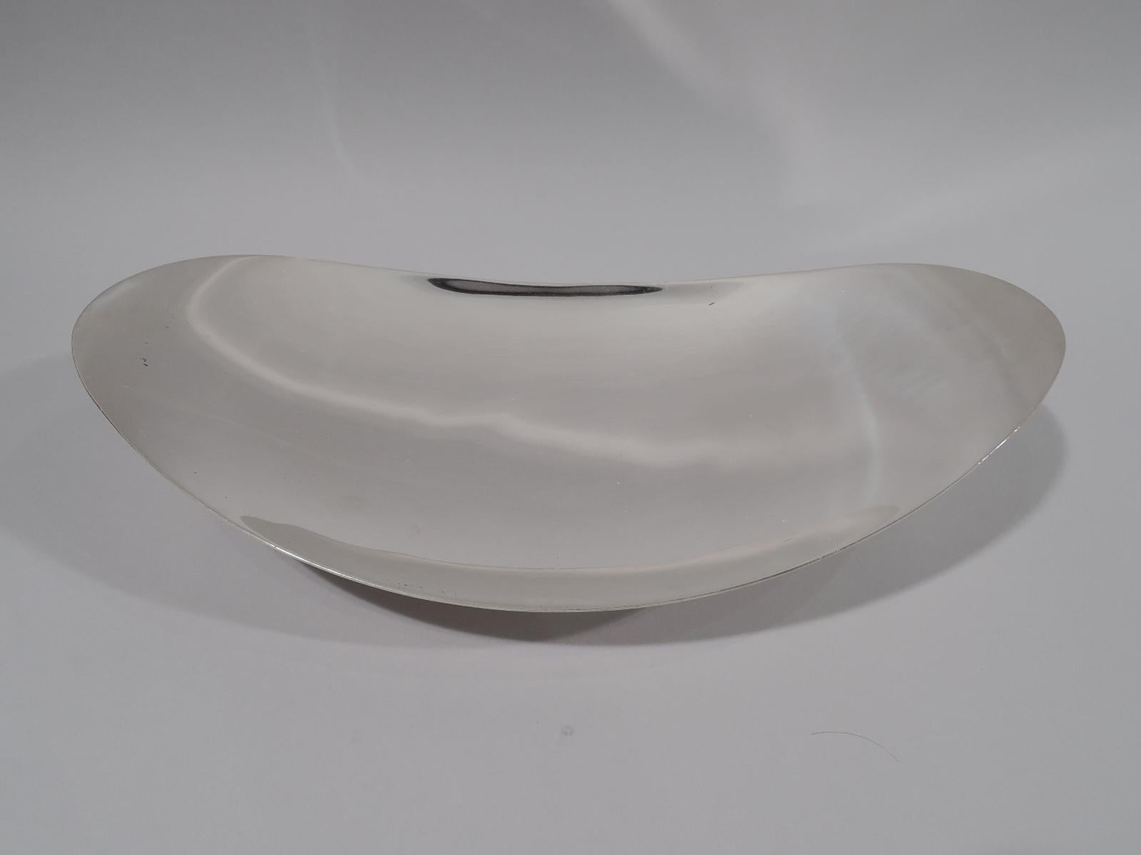Mid-Century Modern sterling silver bowl. Made by Tiffany & Co. in New York. Shallow swooping oval on short and splayed circular foot. Fully marked including pattern 22416 and director’s letter L (circa 1956-1965). Weight: 22.5 troy ounces.