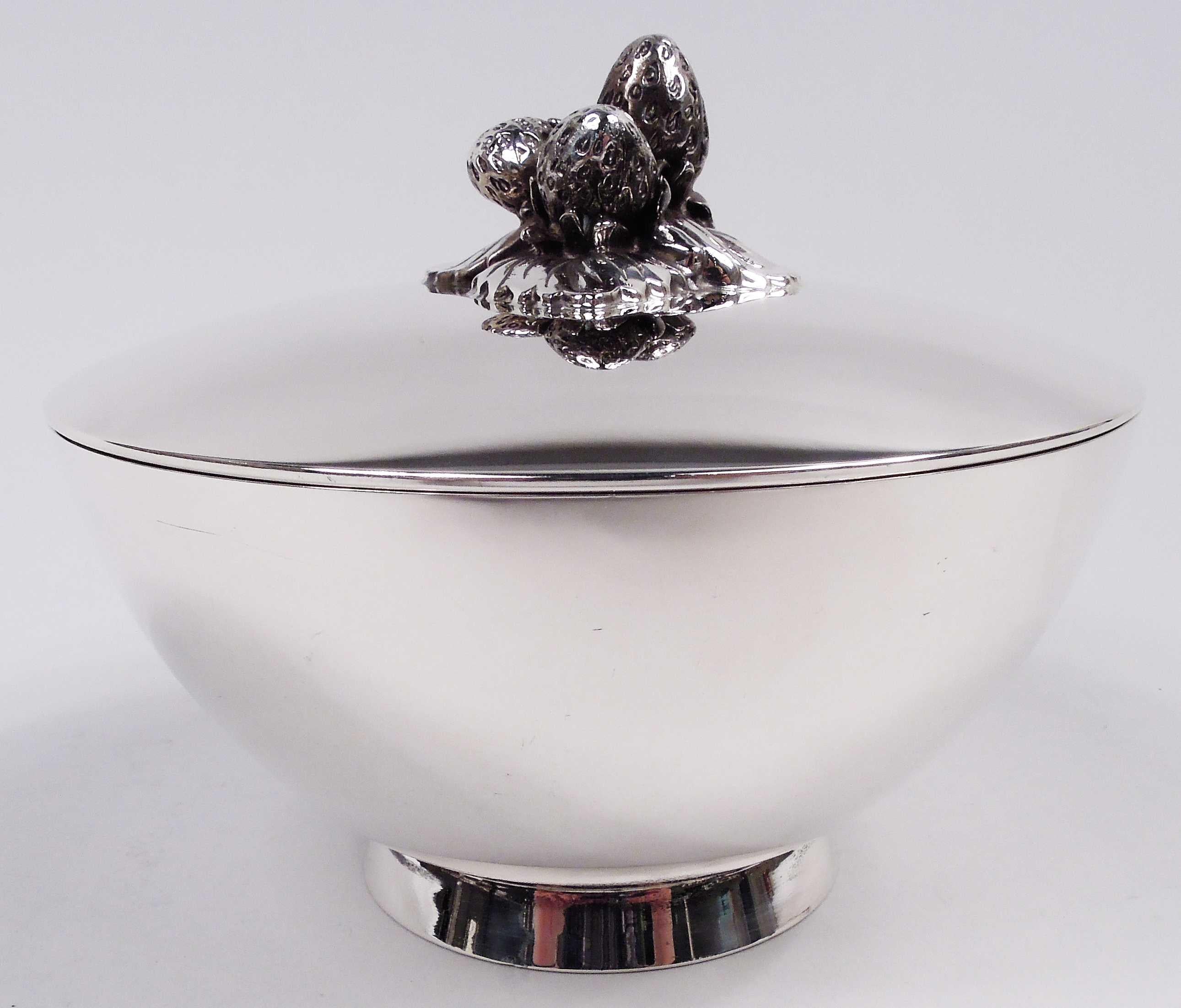 Midcentury Modern sterling silver bowl. Made by Tiffany & Co. in New York. Curved sides and splayed foot ring. Cover top gently curved and mounted with cast strawberry and leaf finial. Fully marked including maker’s stamp, postwar pattern no. 23923,
