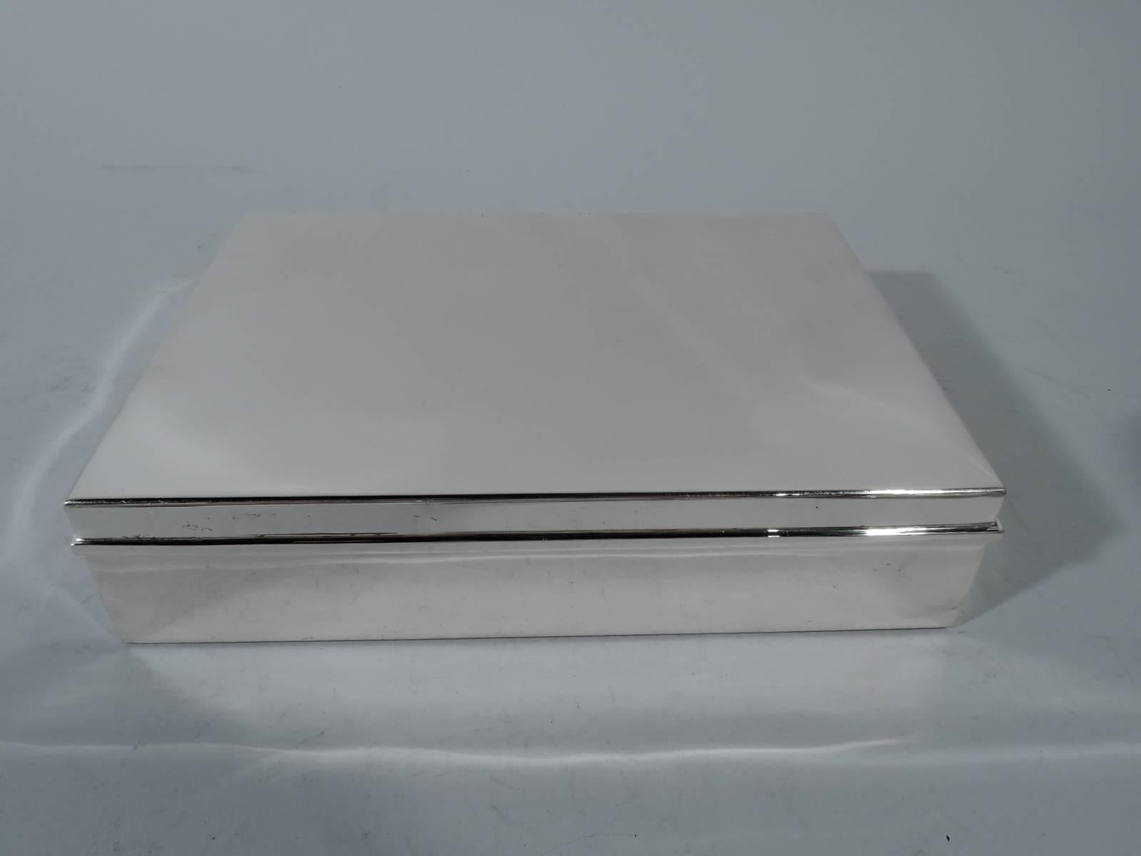 Mid-Century Modern sterling silver box. Made by Tiffany & Co. in New York. Rectangular. Cover flat and hinged with molded rim. Box and cover interior cedar-lined and partitioned. Hallmark includes postwar pattern no. 25318. Heavy gross weight: 46