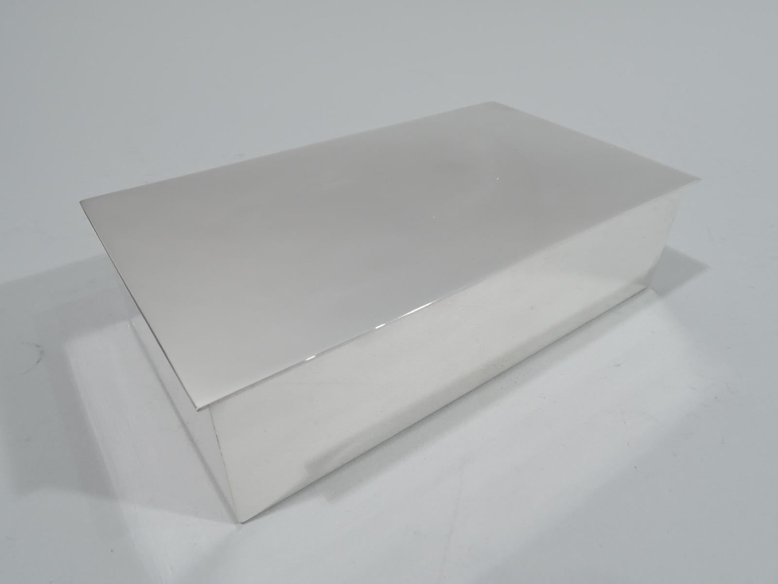 Mid-Century Modern sterling silver box. Made by Tiffany & Co. in New York. Rectangular with straight sides and crisp corners. Cover is hinged and flat with slight overhang. Box interior cedar lined. Austere and functional. Fully marked including