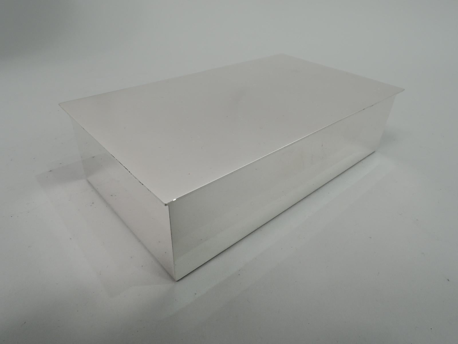 Mid-Century Modern sterling silver box. Made by Tiffany & Co. in New York. Rectangular with straight sides and crisp corners. Cover is hinged and flat with slight overhang. Box interior cedar lined. Fully marked including maker’s stamp and postwar