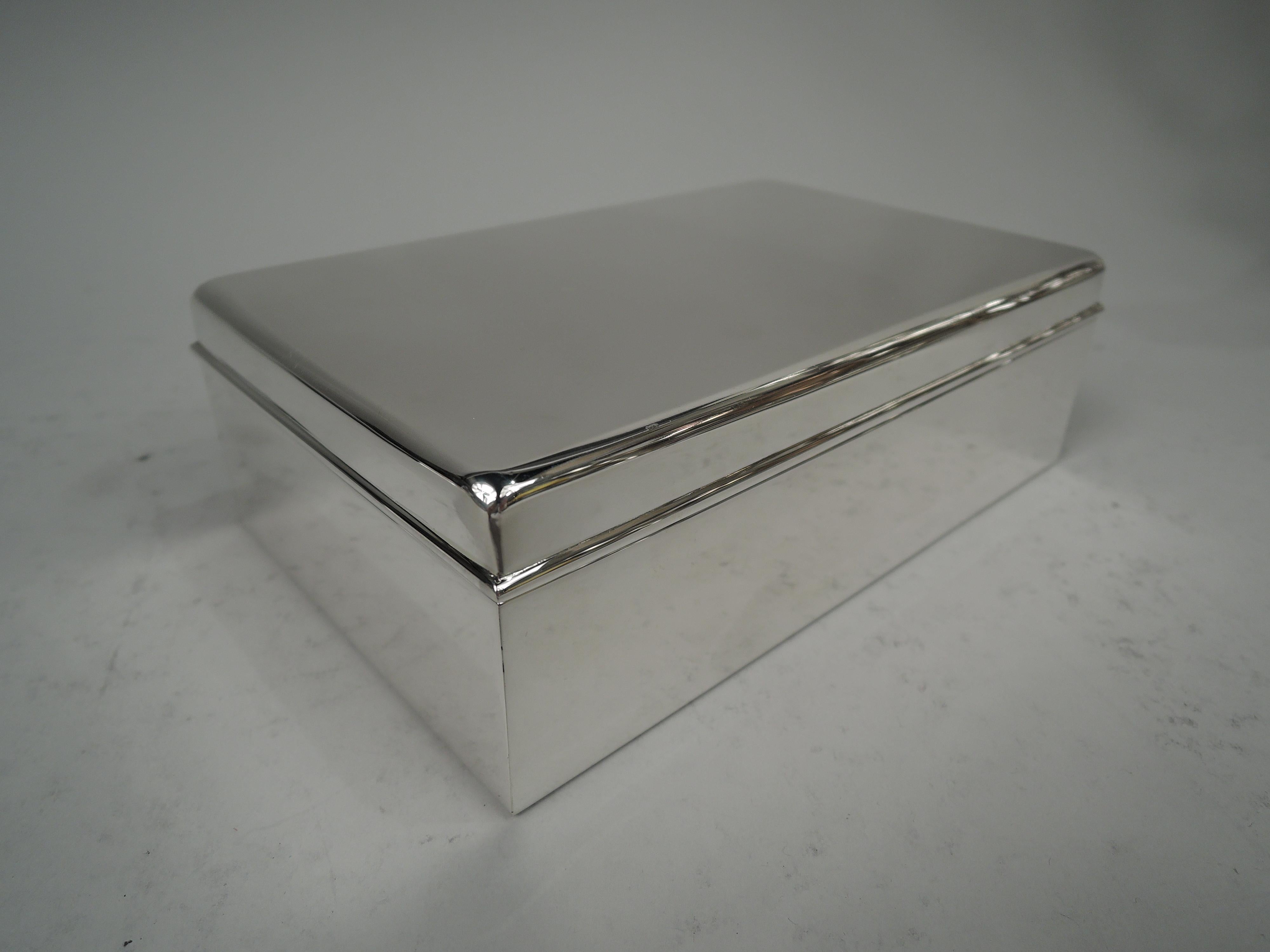 Midcentury Modern sterling silver box. Made by Tiffany & Co. in New York. Rectangular with straight sides. Cover has flat top and molded rim. Box interior cedar-lined and partitioned. Cover interior gilt washed. Fully marked including maker’s stamp