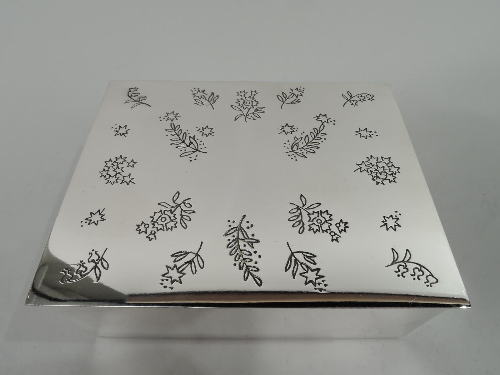 Mid-Century Modern sterling silver jewelry box. Made by Tiffany & Co. in New York. Rectangular with straight sides. Cover flat, hinged and overhanging. Cover top engraved with scattered flowers. Box interior velvet lined. Fully marked including