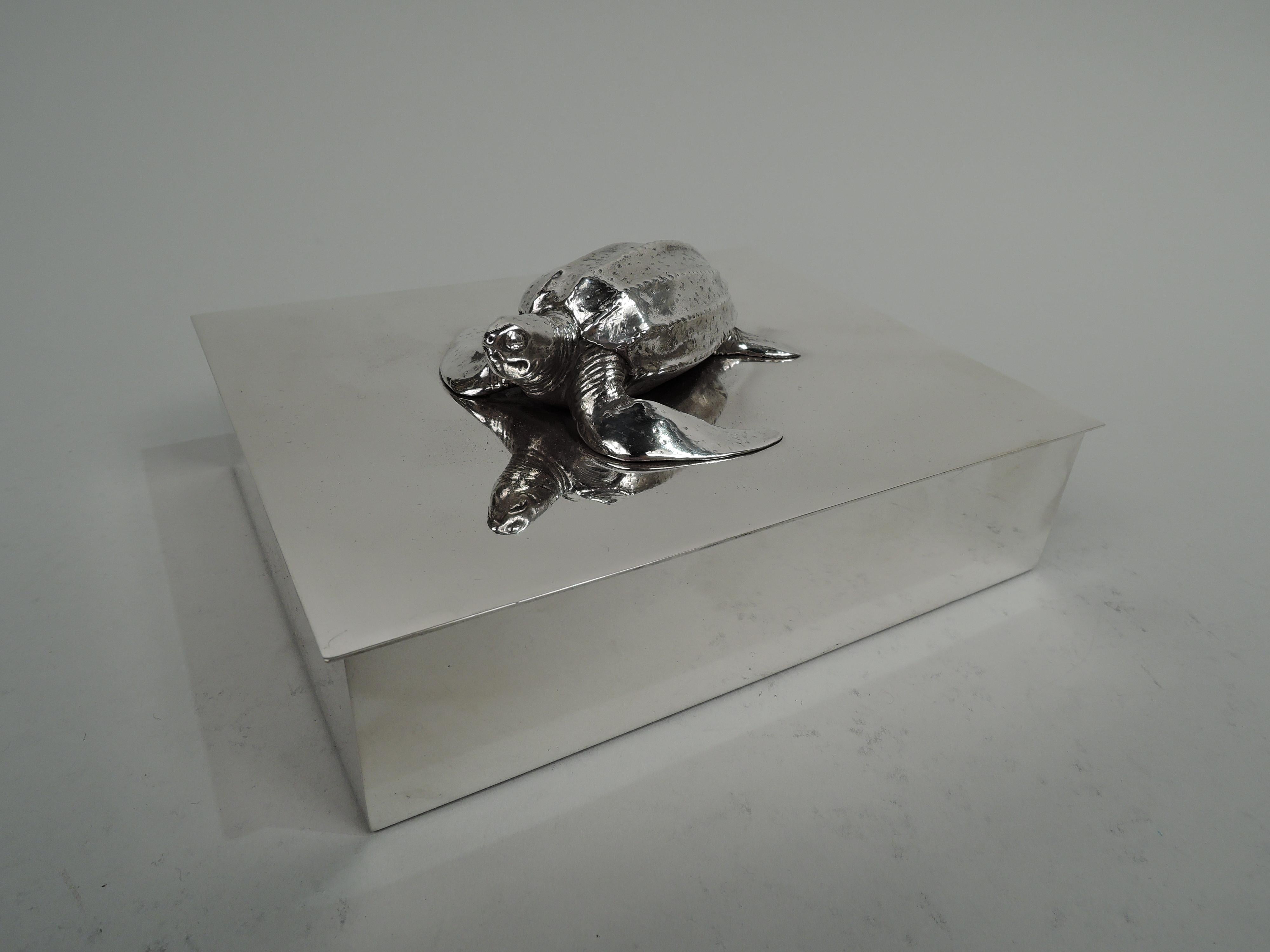Mid-Century Modern sterling silver box. Made by Tiffany & Co. in New York. Rectangular with straight sides and crisp corners. Cover flat and hinged with slight overhang. On top is mounted cast figure of a turtle with out-stretched head and webbed