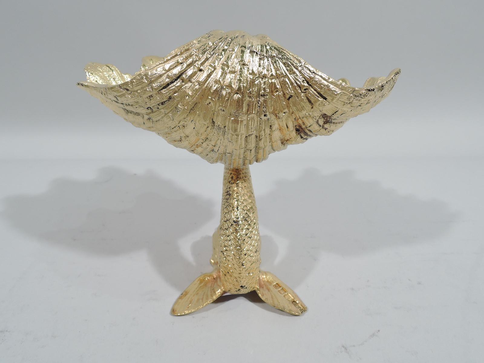 Modern Classical gilt sterling silver soap dish. Made by Tiffany & Co. in London in 1960. Irregular and corrugated scallop shell mounted to dolphin with scaly body and splayed fins. English marks as well as “Tiffany & Co. / England / Sterling”.
