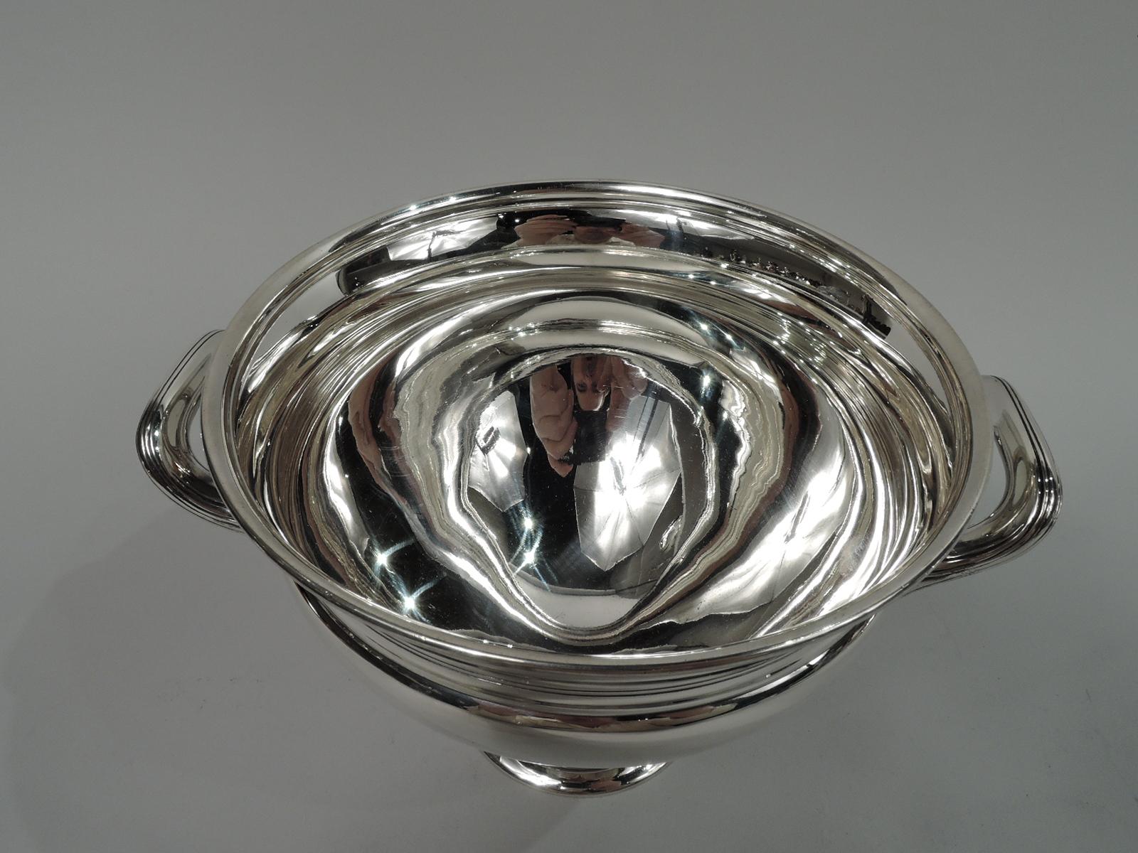 Modern Classical sterling silver bowl. Made by Tiffany & Co. in New York, ca 1921. Tapering with inset neck and flared rim. Reeded bracket side handles. Raised foot. Incised linear bands. Fully marked including maker’s stamp, pattern no. 19847