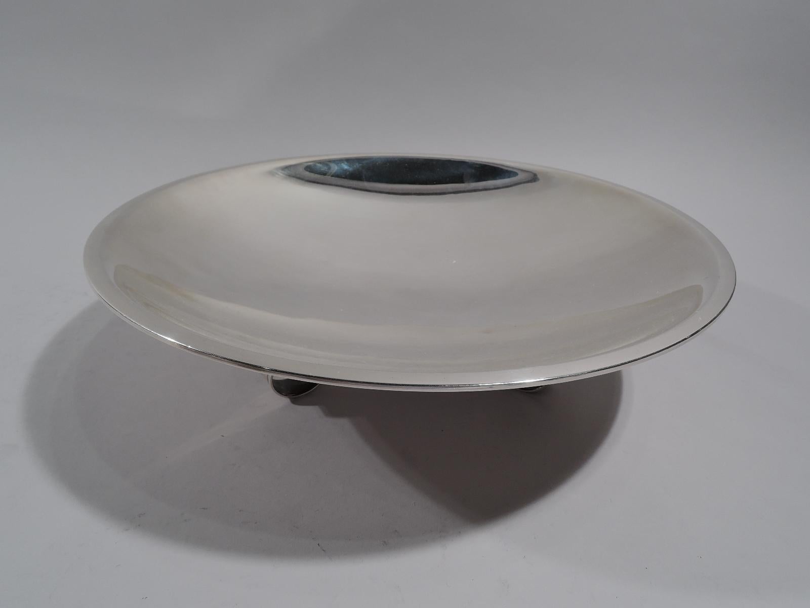 Modern Classical sterling silver centerpiece bowl. Made by Tiffany & Co. in New York. Round and shallow with flat rim. Three s-scroll and bead supports. Fully marked including pattern no. 23228 (first produced in 1946) and director’s letter M