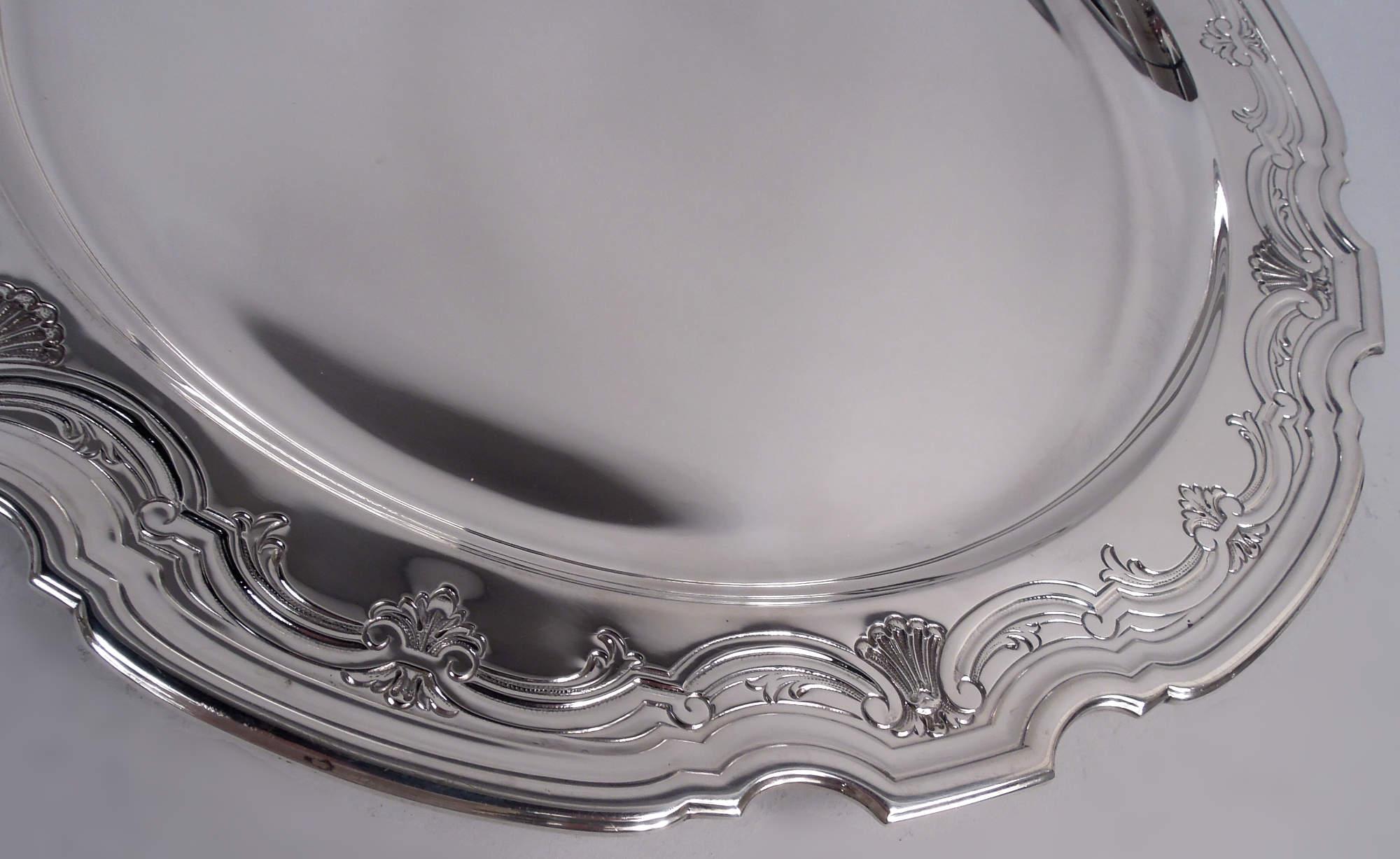 Modern Georgian sterling silver tray. Made by Tiffany & Co. in New York, ca 1924. Deep and plain well. Shoulder has chased scroll and shell rim. Molded curvilinear piecrust rim. Fully marked including maker’s stamp, pattern no. 20350H (first