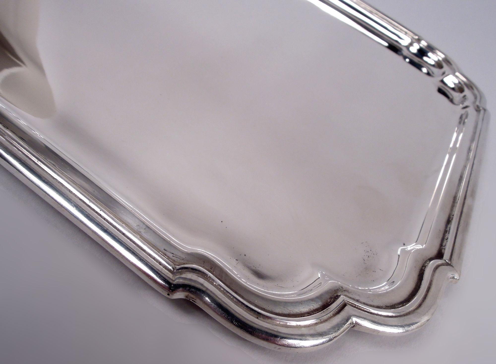 Georgian-inspired sterling silver tray. Made by Tiffany & Co. in New York. Rectangular with stepped molded rim and double c-scroll corners. A great Midcentury adaptation of 18th-century design. Fully marked including maker’s stamp and postwar