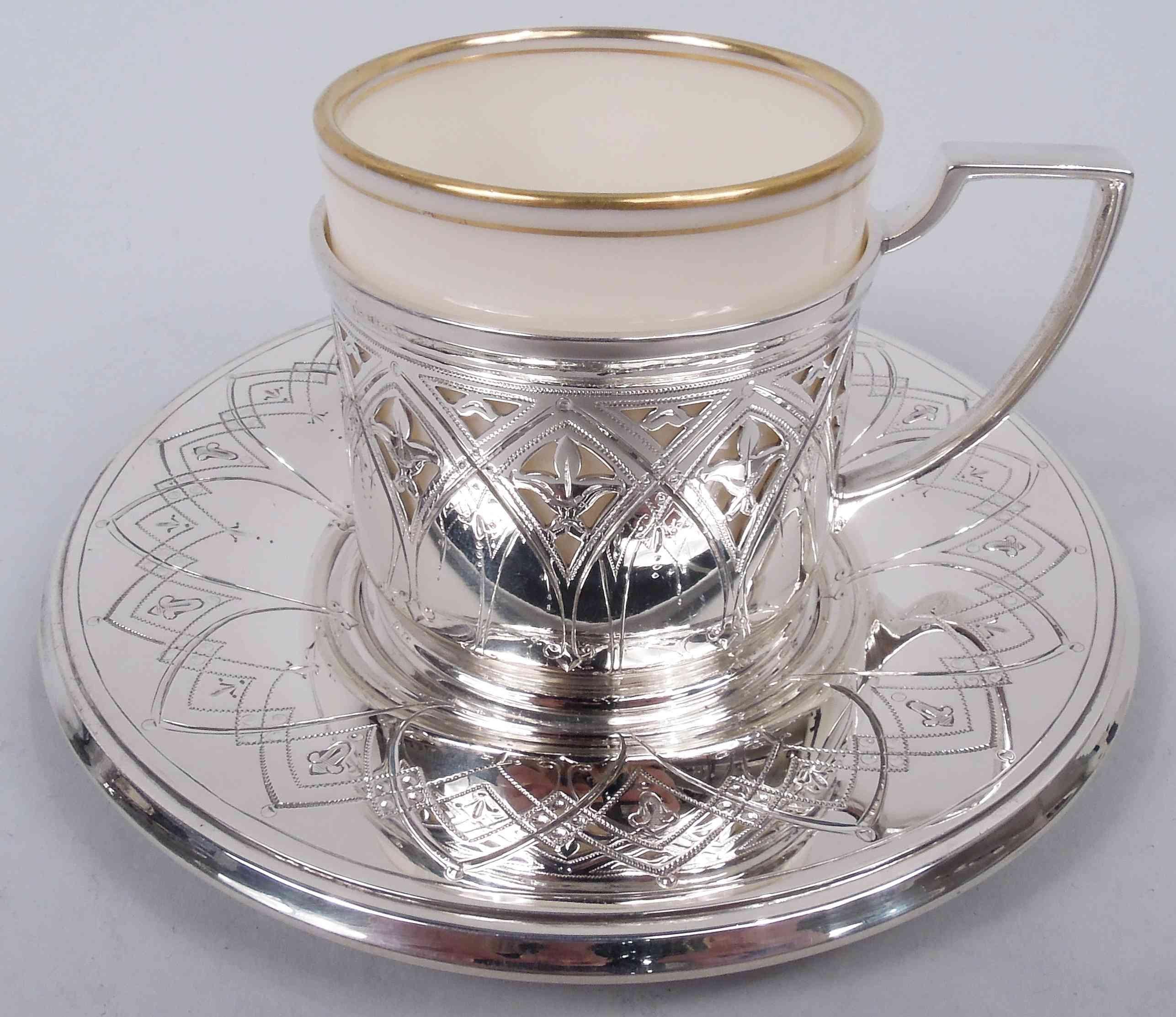 Set of 12 Modern Gothic sterling silver demitasse holders. Made by Tiffany & Co. in New York, 1927. Each holder: Drum-form holder with stepped rims. Each saucer: Deep plain well and canted rim. Engraved interlaced arcade with stylized pendant