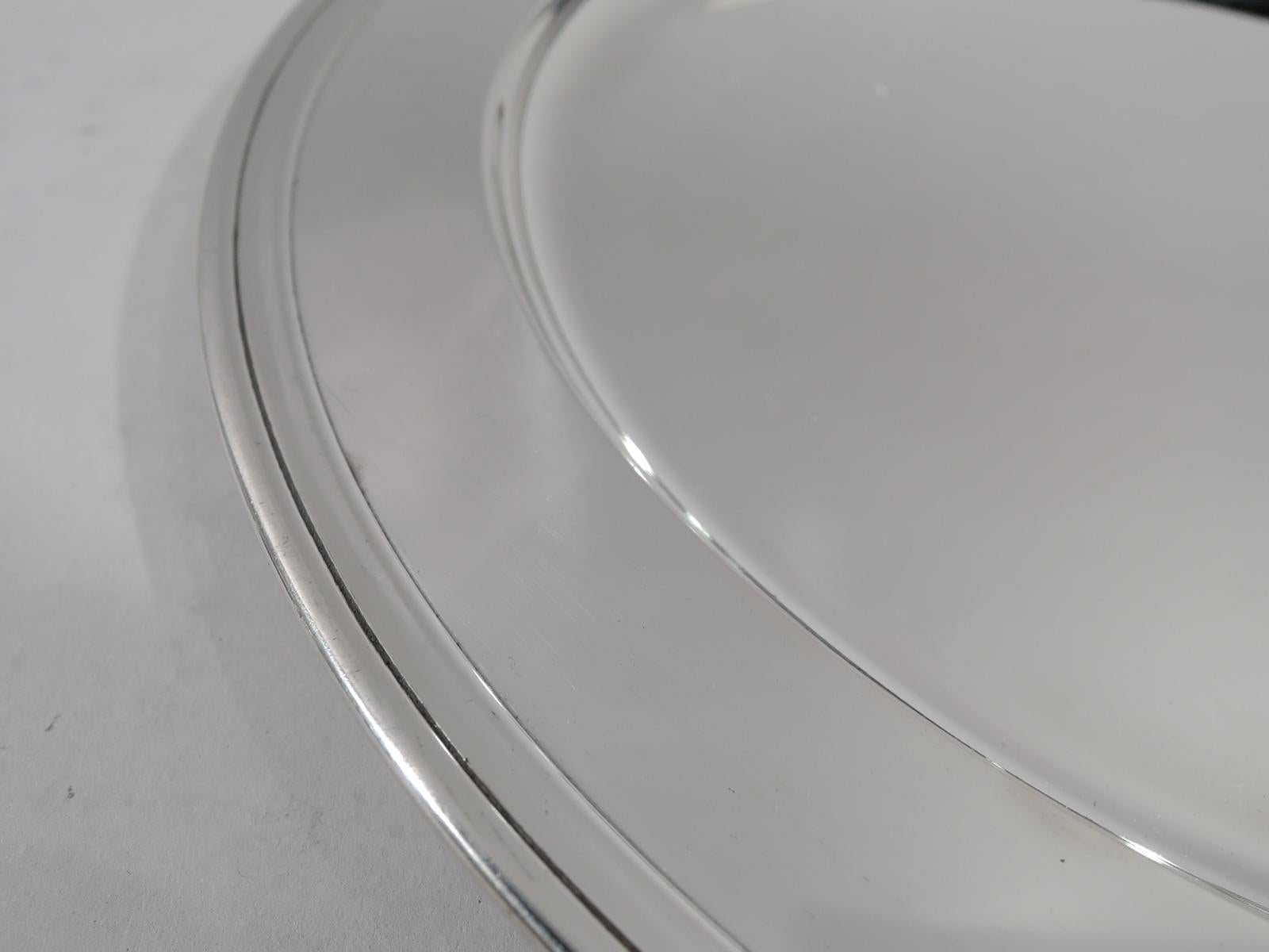 Modern sterling silver serving tray. Made by Tiffany & Co. in New York, circa 1923. Round with well and molded rim. Fully marked including pattern no. 20185 (first produced in 1923), director’s letter m, and diameter. Weight: 15.5 troy ounces.