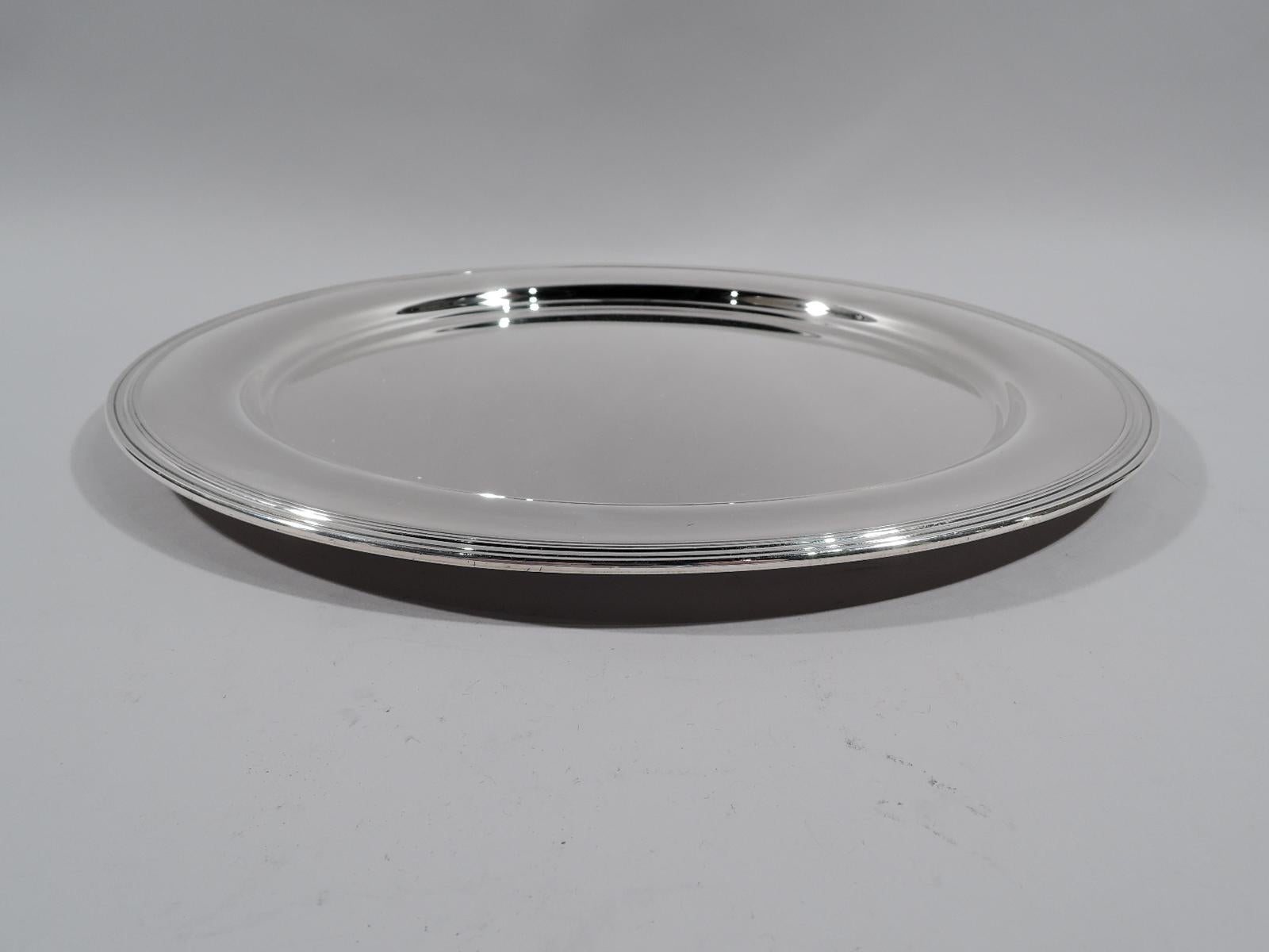 Modern sterling silver serving tray. Made by Tiffany & Co. in New York, circa 1920. Round well, curved shoulder, and reeded rim. Fully marked including pattern no. 5765G, director’s letter m, and diameter. Weight: 26.5 troy ounces. Measures: 13 inch.