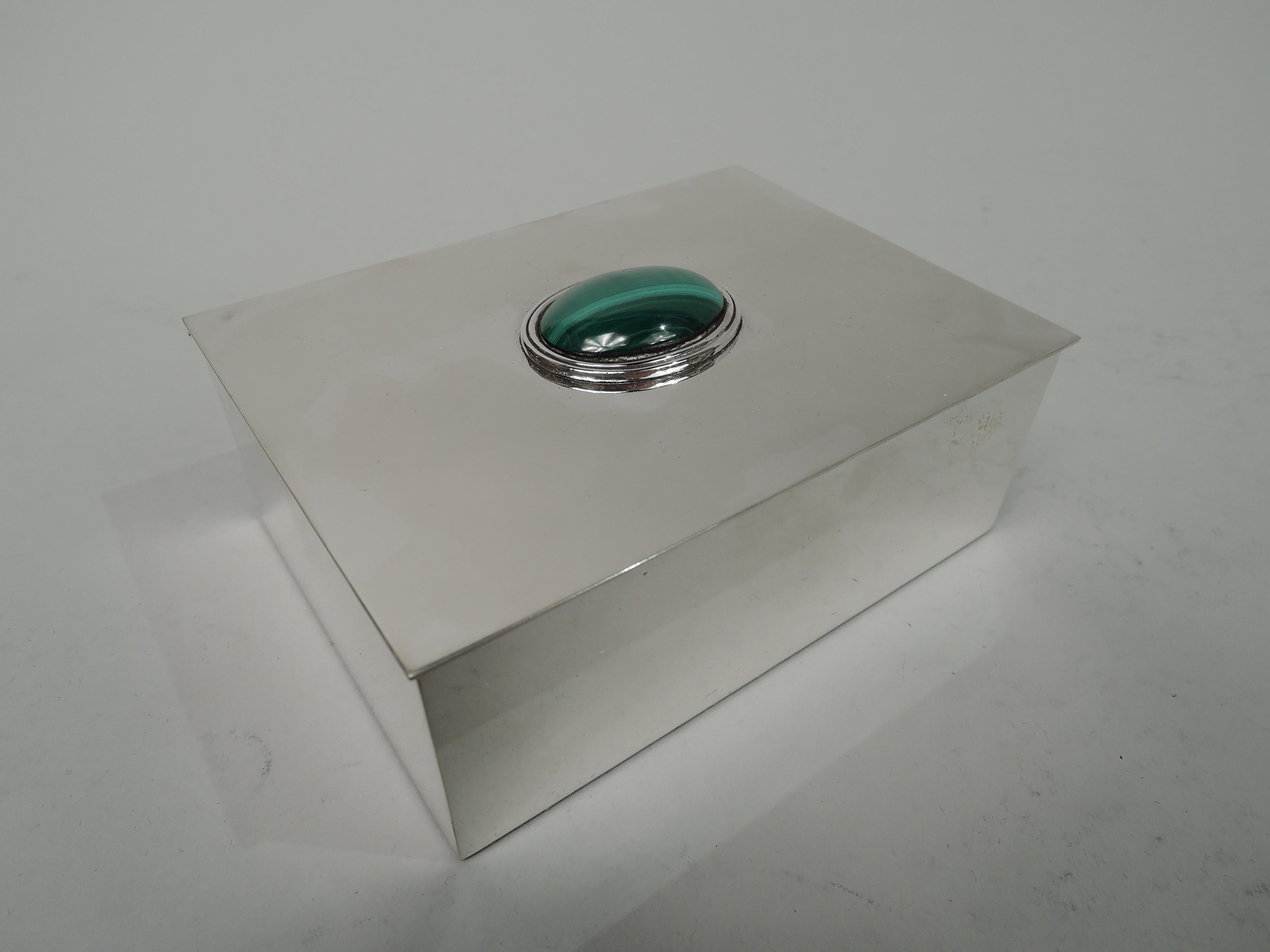 Modern sterling silver box. Retailed by Tiffany & Co. In New York. Rectangular with straight sides and crisp corners. Cover flat and hinged with slight overhang; cabochon malachite oval in reeded mount on cover top. Fully marked including retailer’s