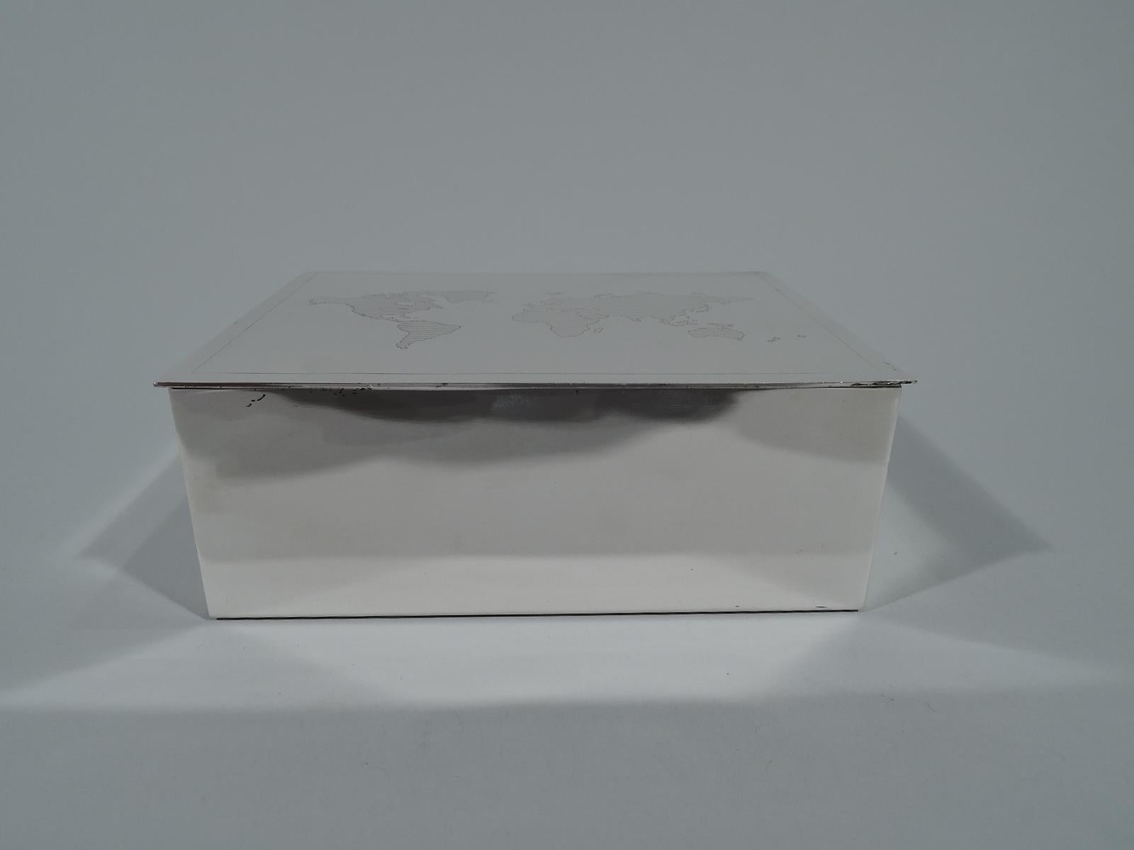 Modern sterling silver box. Retailed by Tiffany & Co. in New York. Rectangular with straight sides and flat and hinged cover. On cover is engraved map of world with linear shading. Box interior cedar lined. Italian hallmark with retailer’s stamp.