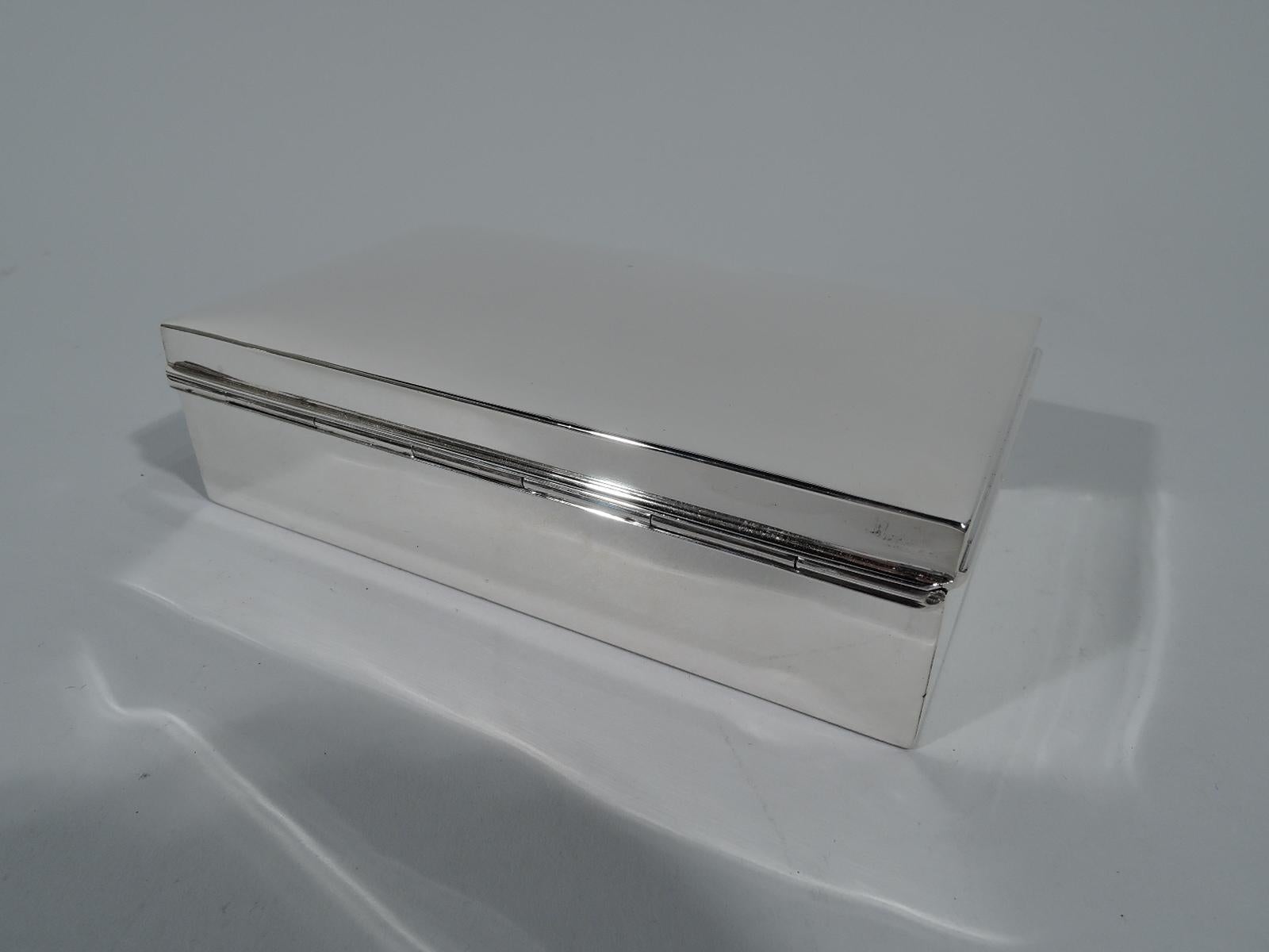 Modern sterling silver desk box. Retailed by Tiffany & Co. in New York. Rectangular with straight sides and gently curved and hinged cover with molded rim. Box interior cedar lined. Cover interior gilt-washed. Hallmarked. Gross weight: 8 troy ounces.