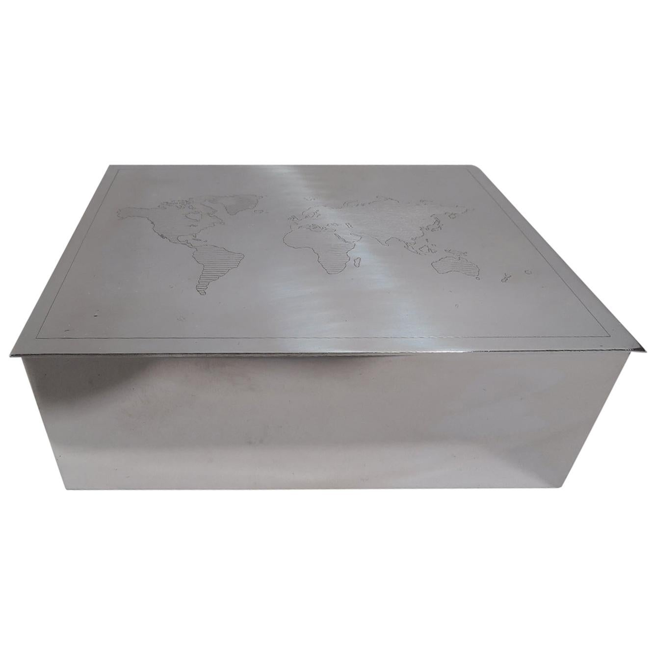 Modern sterling silver box. Retailed by Tiffany & Co. in New York. Rectangular with straight sides and flat and hinged cover. On cover is engraved map of world with linear shading. Box interior cedar lined. A great gift for someone who is going