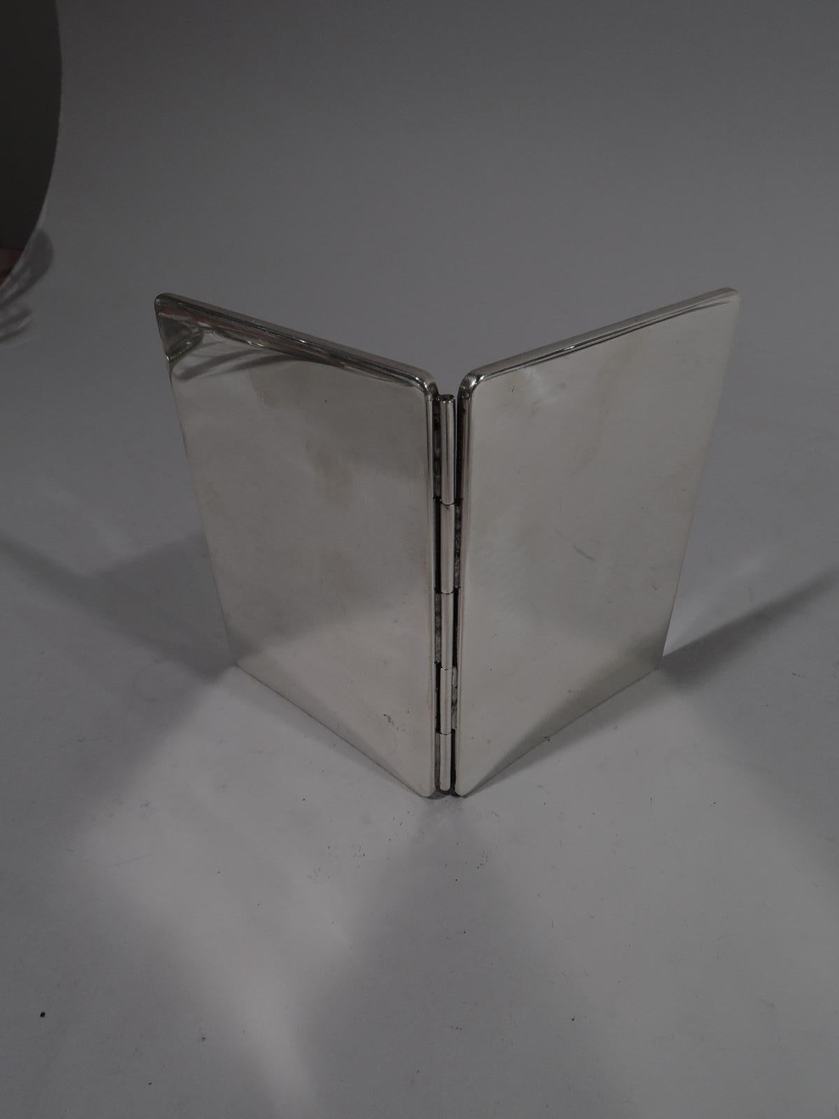 Mid-Century Modern sterling silver traveling twosome picture frame. Retailed by Tiffany & Co. in New York. Two hinged frames. Each: Oval window in rectangular surround with rounded corners. Marked “Tiffany & Co. / Sterling / 925”.

Dimensions: