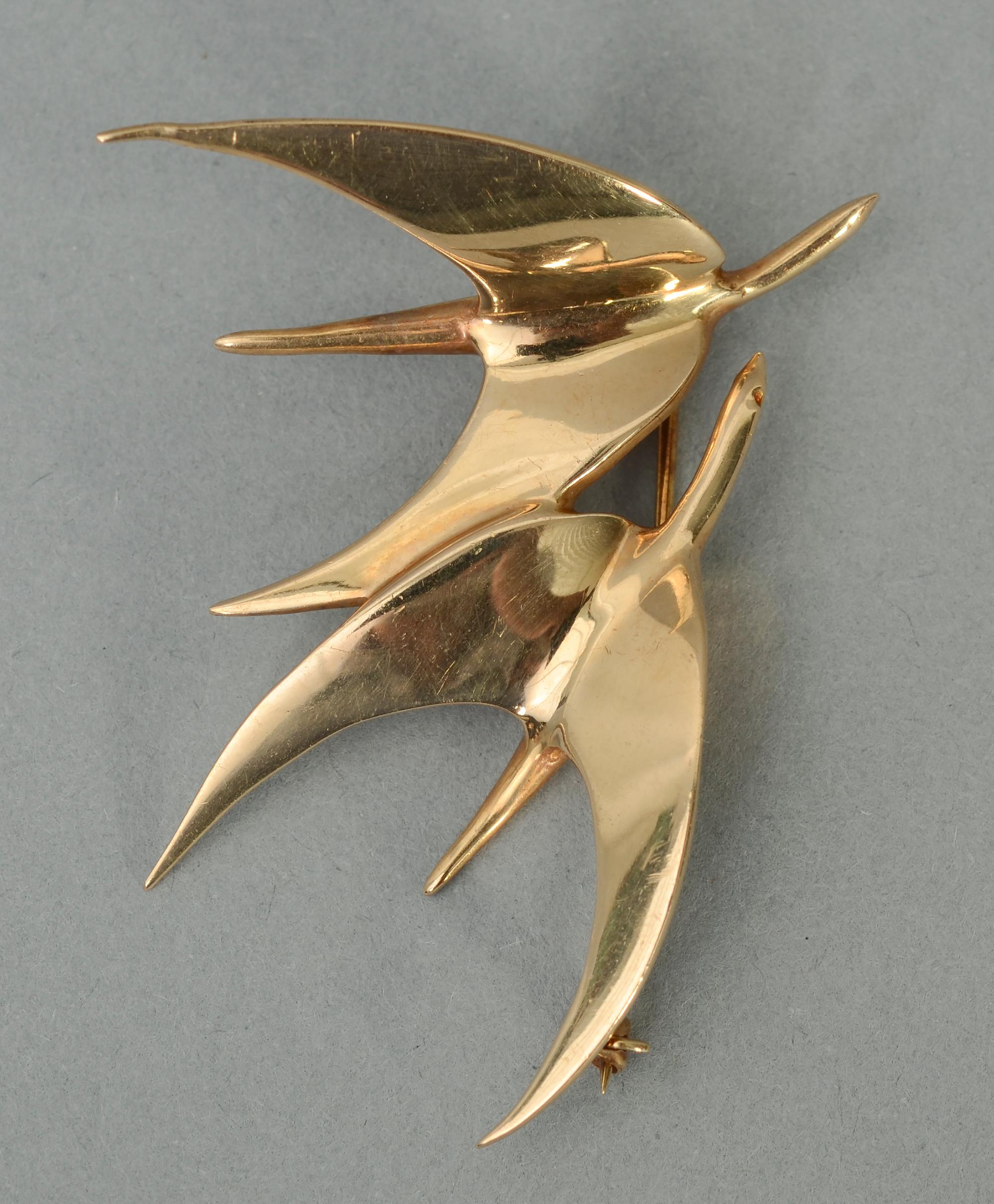 This Tiffany brooch depicting two birds in flight is the ultimate in Modernist abstraction and minimalism. Streamlined as it is, it very effectively conveys the movement of the pair.
The brooch is 2 1/4 inches in width and 2 1/8 inches tall. It can