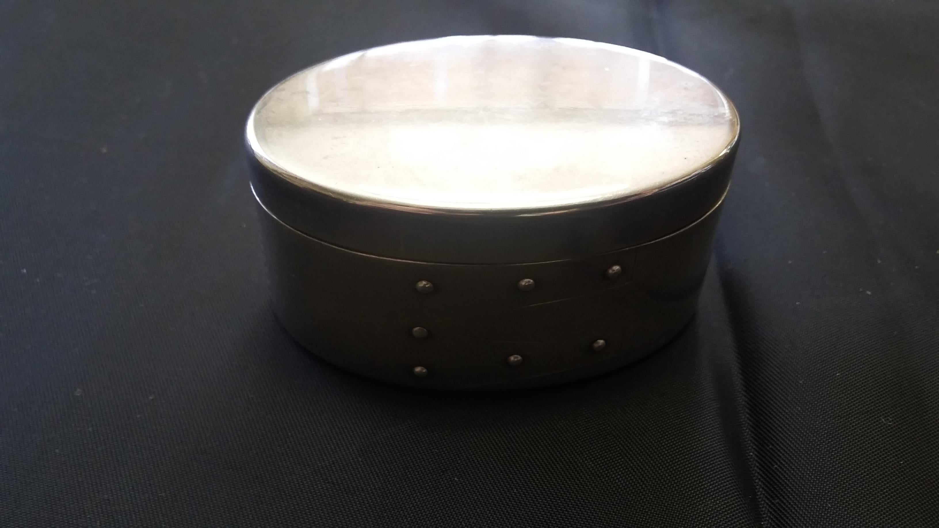A beautiful small oval sterling silver box. In the style of a shaker box. Signed on the bottom as well as signed Tiffany & Co. on the inside rim of the bottom piece. Has a blue velvet lining. Great little quality item.