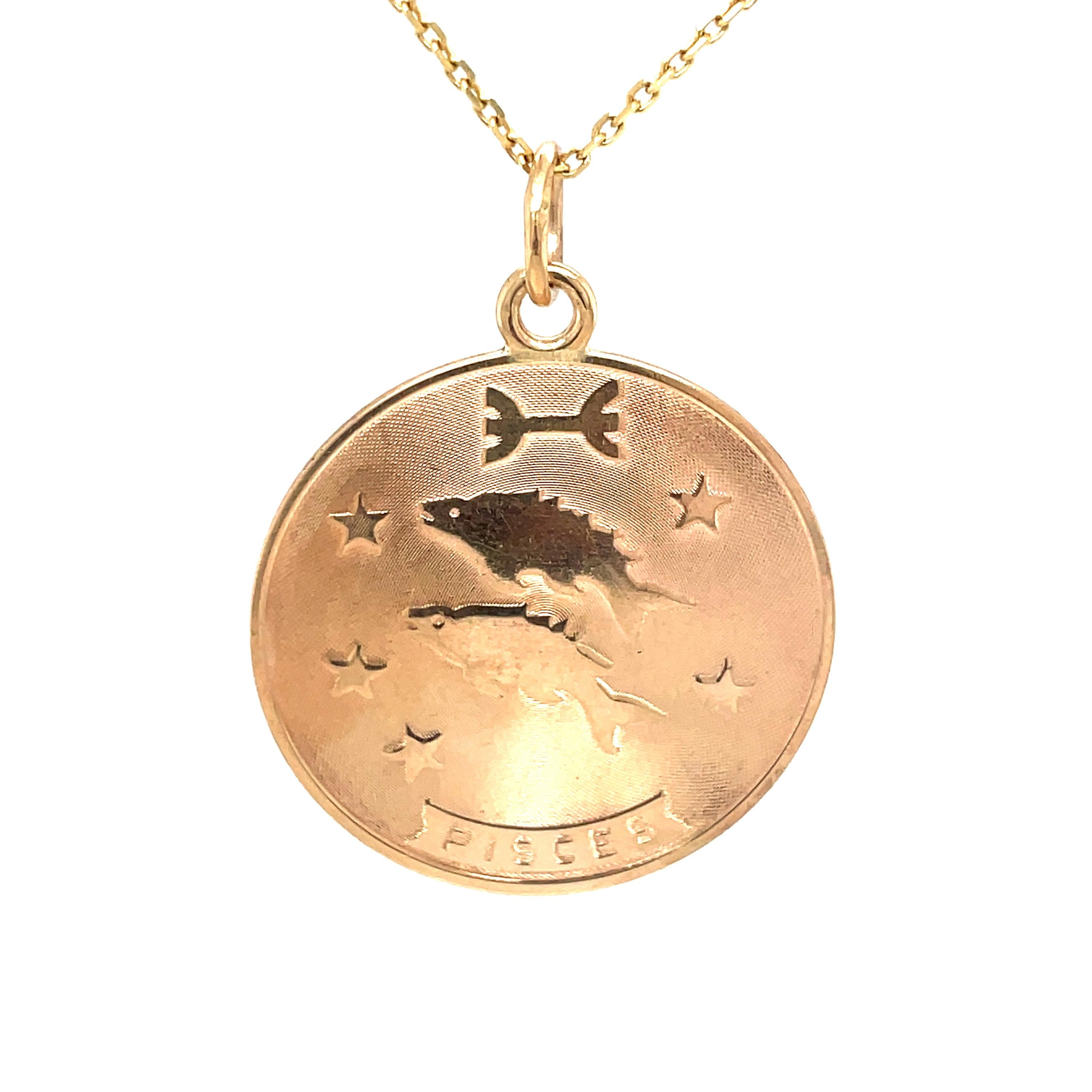 A very appealing Pisces charm/pendant.  Made and signed by TIFFANY & CO.  Two applied figural fish, the word Pisces and the zodiac sign are all in shiny 14K yellow gold, set on a textured background.  Very attractive configuration.  1