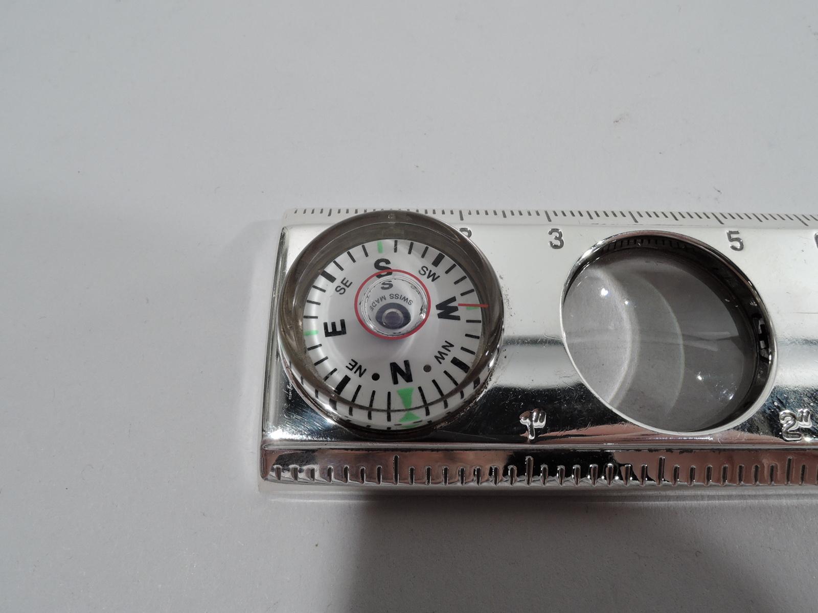 Portable multipurpose measuring device. Retailed by Tiffany & Co. in New York. Double-edged ruler in inches and centimeters inset with compass, magnifying glass, and thermometer. Marked “Tiffany & Co. 925”.