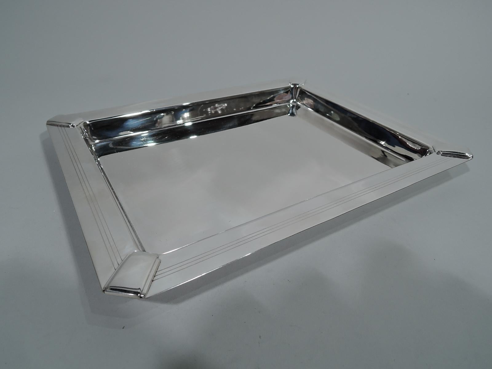 Retro-style sterling silver rectangular tray. Retailed by Tiffany & Co. in New York. Deep rectangular well with chamfered corners. Wide and flat rim with engraved wraparound rim and skyscraper motif applied to corners. Stylish Art Deco revival.